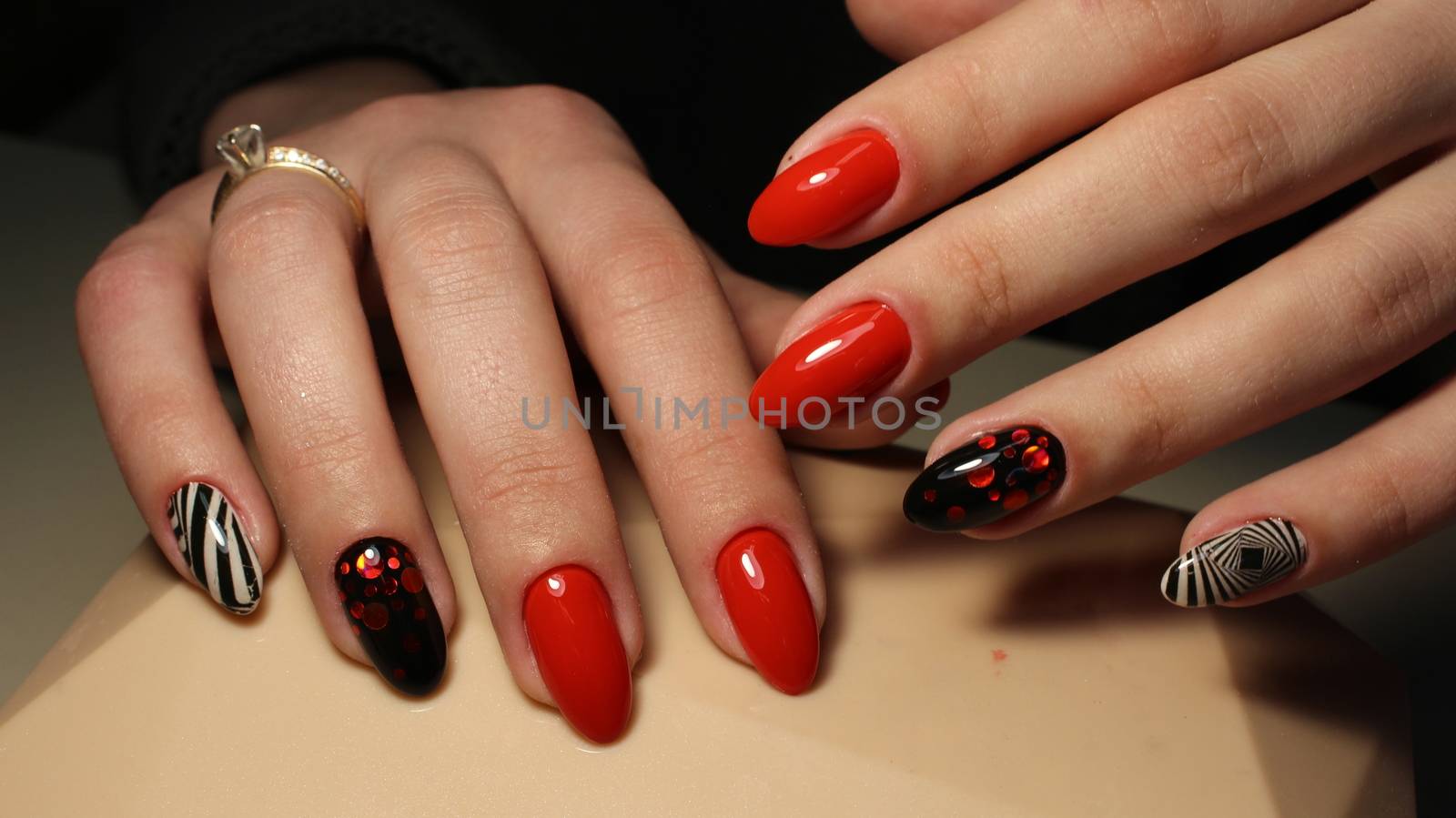 Manicure, design red with black and white geometric abstraction on nails