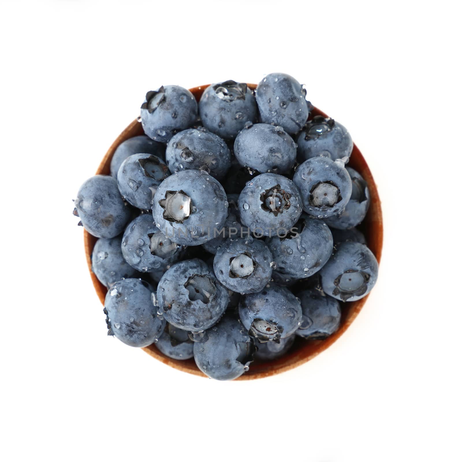 Portion of fresh washed blueberry berries in rustic wooden bowl, wet with water drops, isolated on white background, close up, elevated top view, directly above