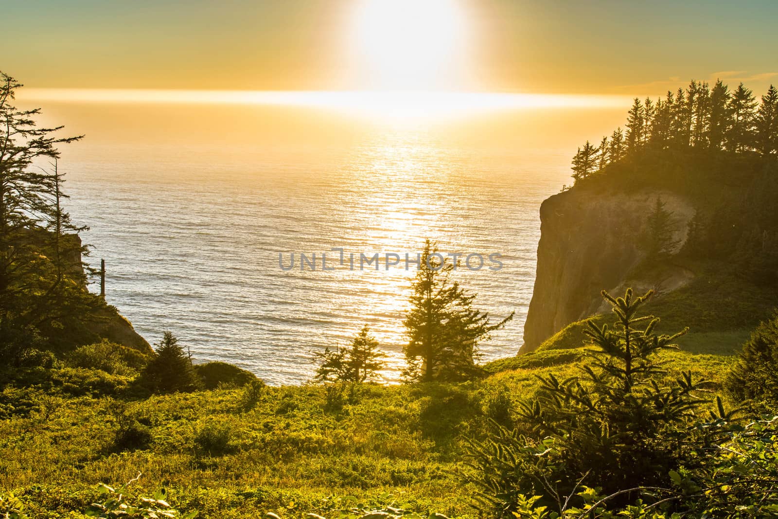 Taken from the roadside looking between two cliffs at the sun setting over the Pacific Ocean