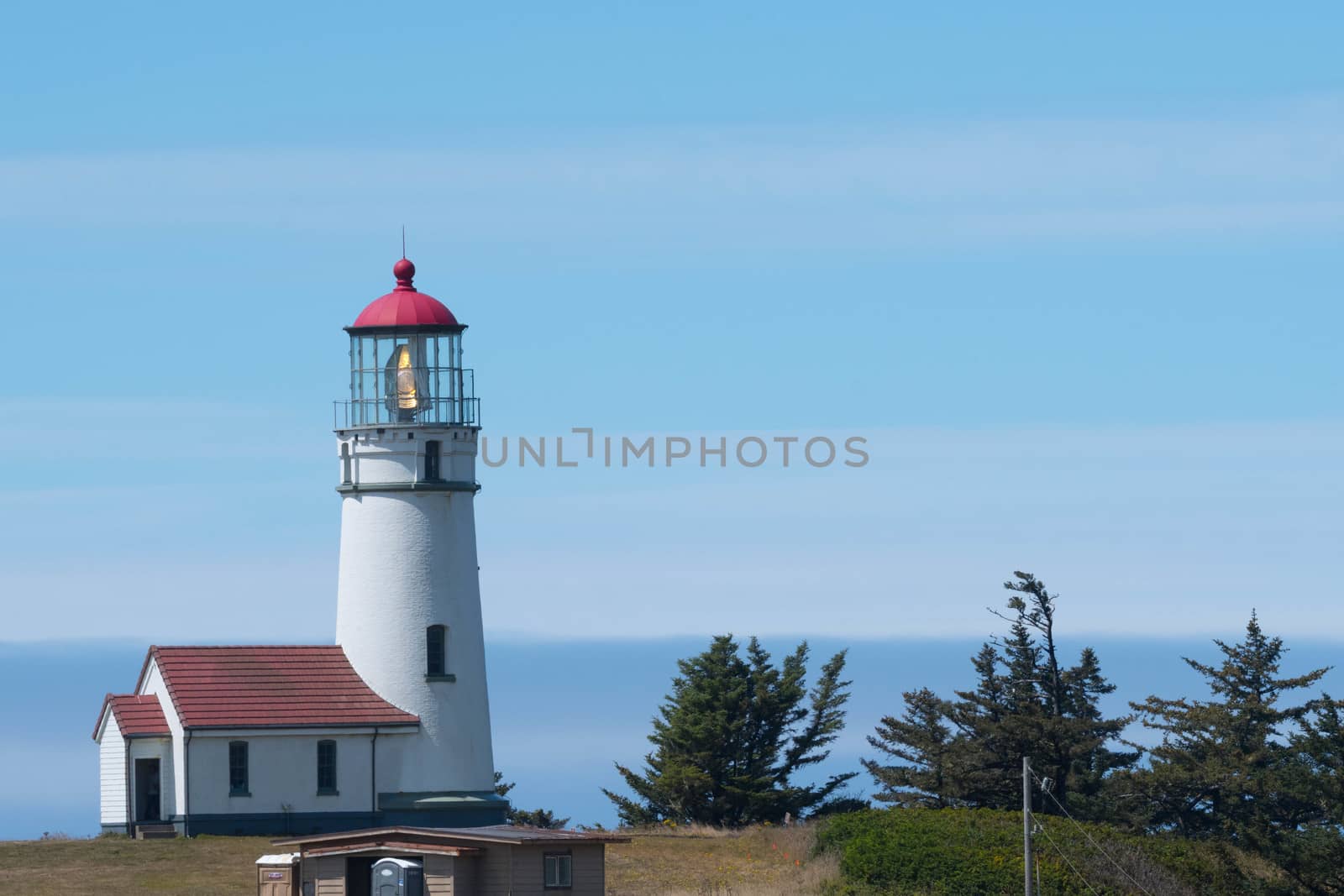 Pacific Ocean view of Cape Blanco Lighthouse on sunny day.