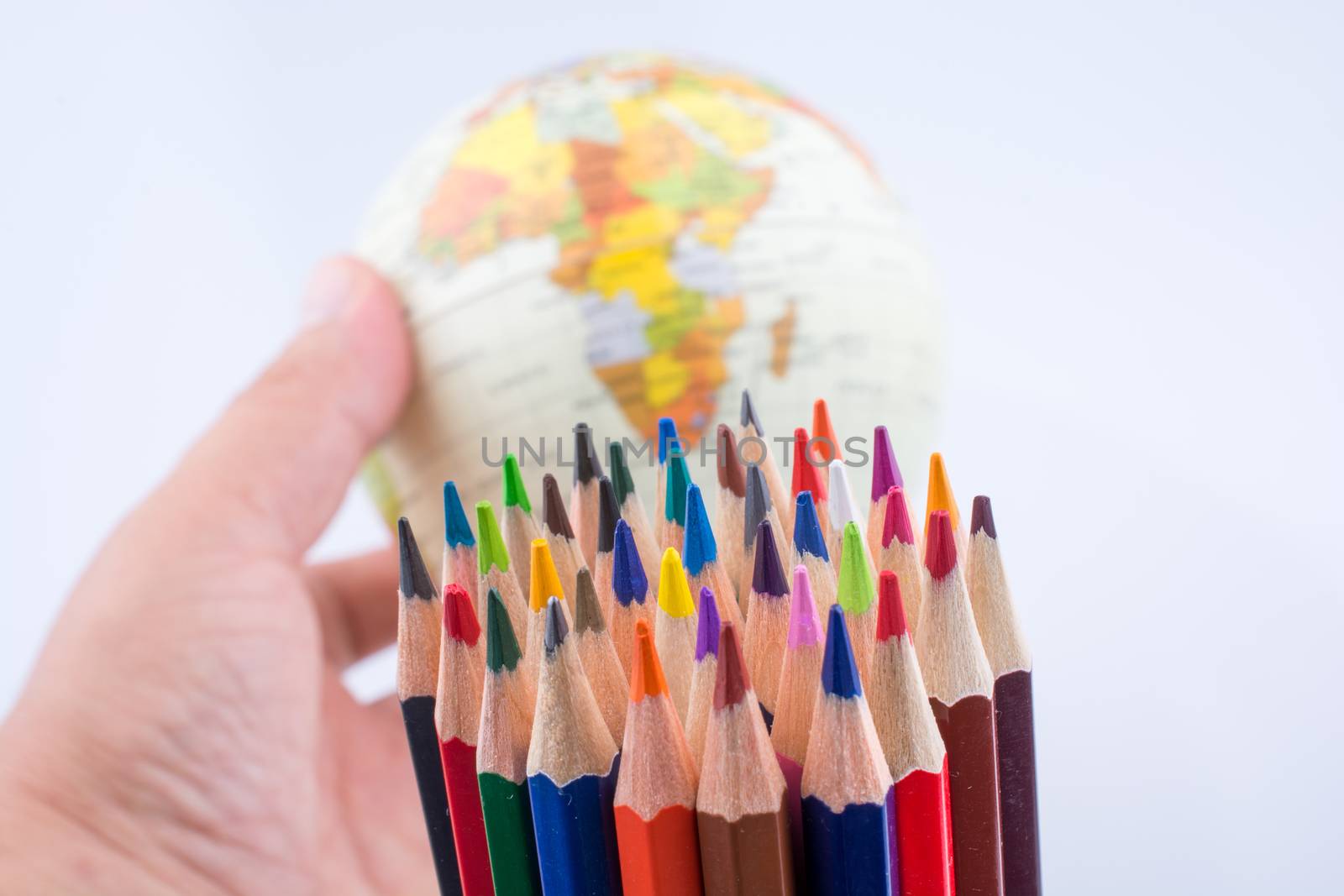 Color pencils of various color and globe on white background