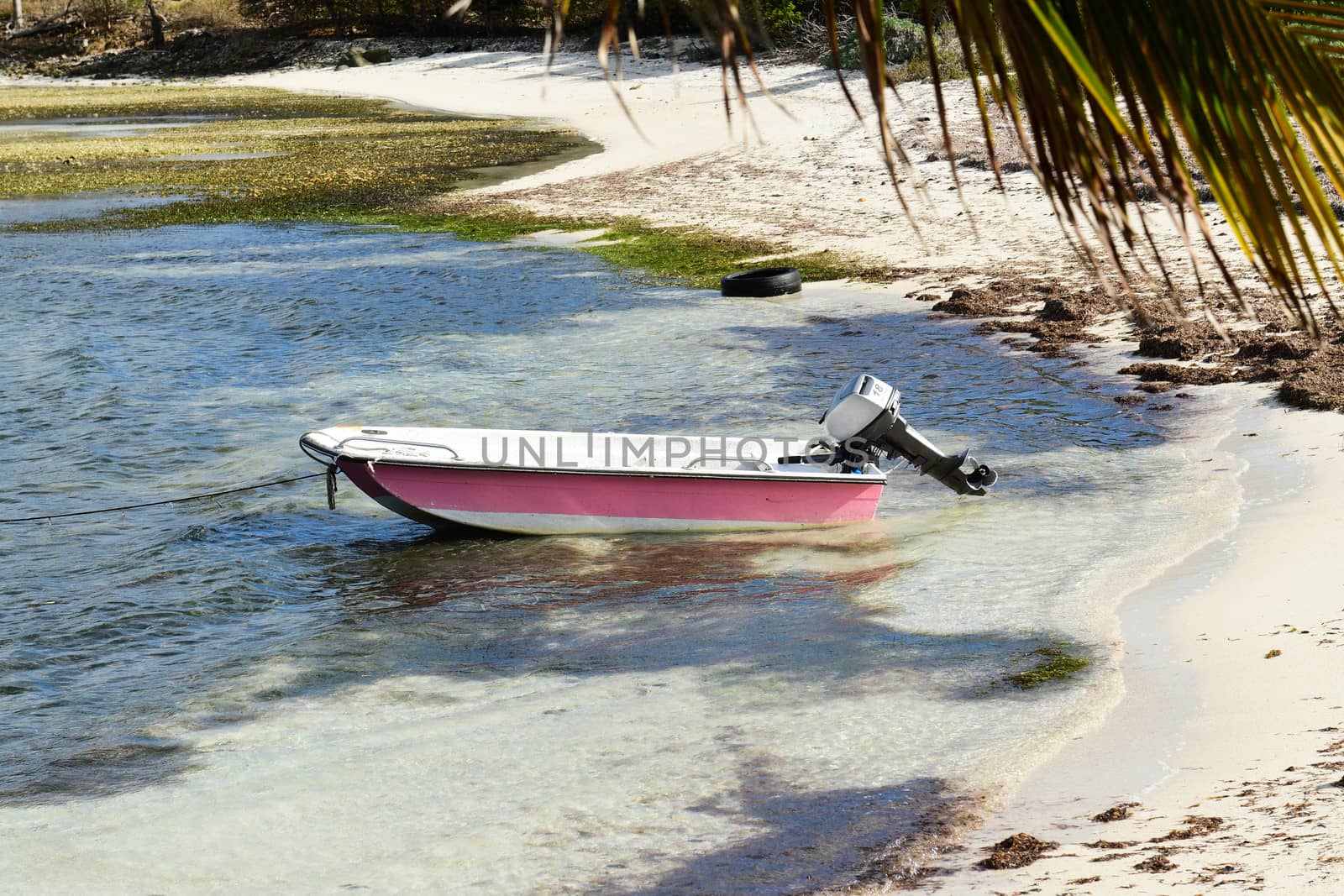 Dinghy with outboard moored in shallow water on British Virgin Islands beach