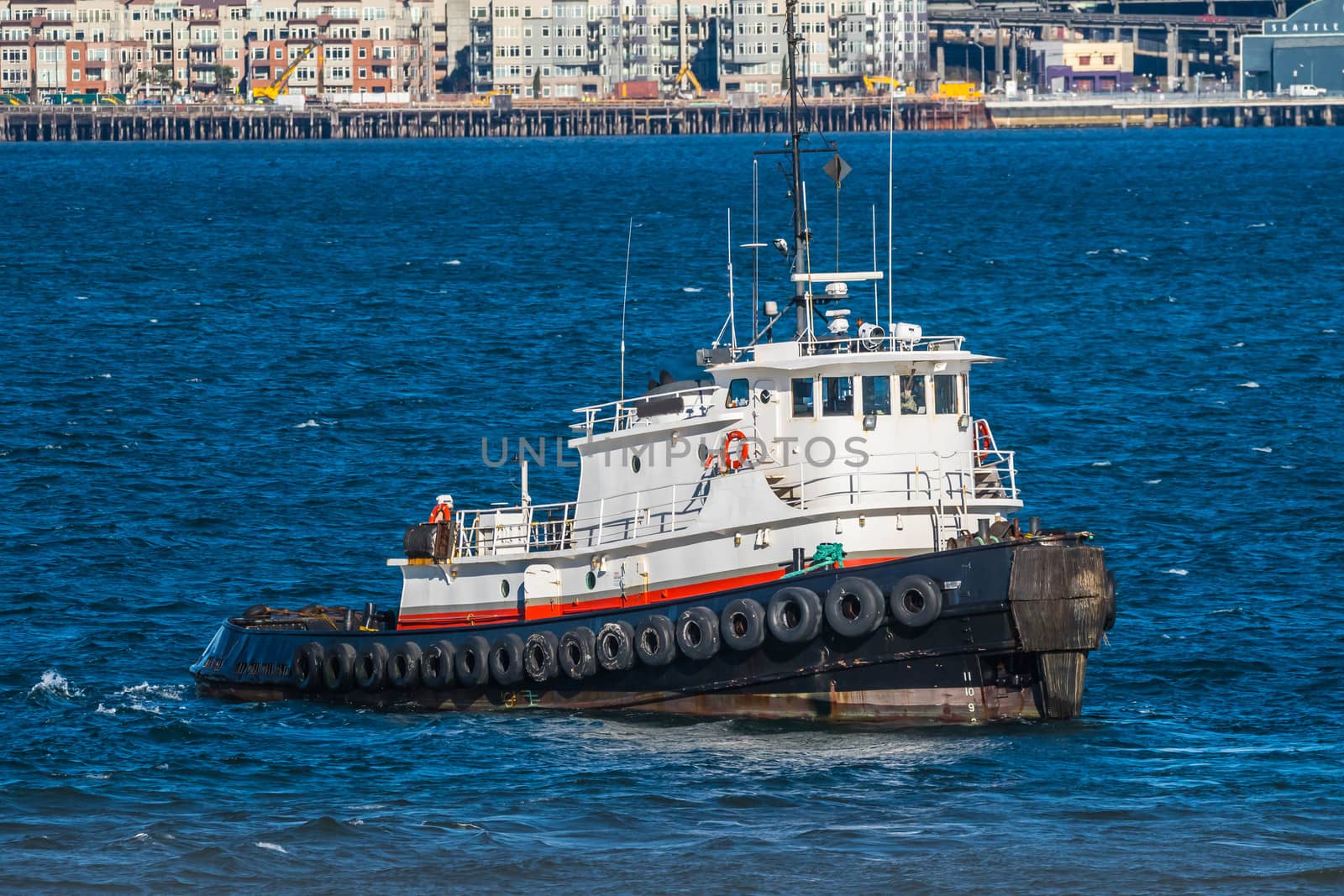 Old tug in Seattle harbot with blue water and a few whitecaps.