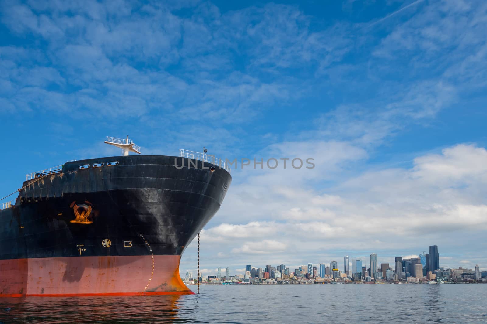 Bulk Carrier at anchor in Seattle's Elliott Bay on Sunny, windless day with city in background