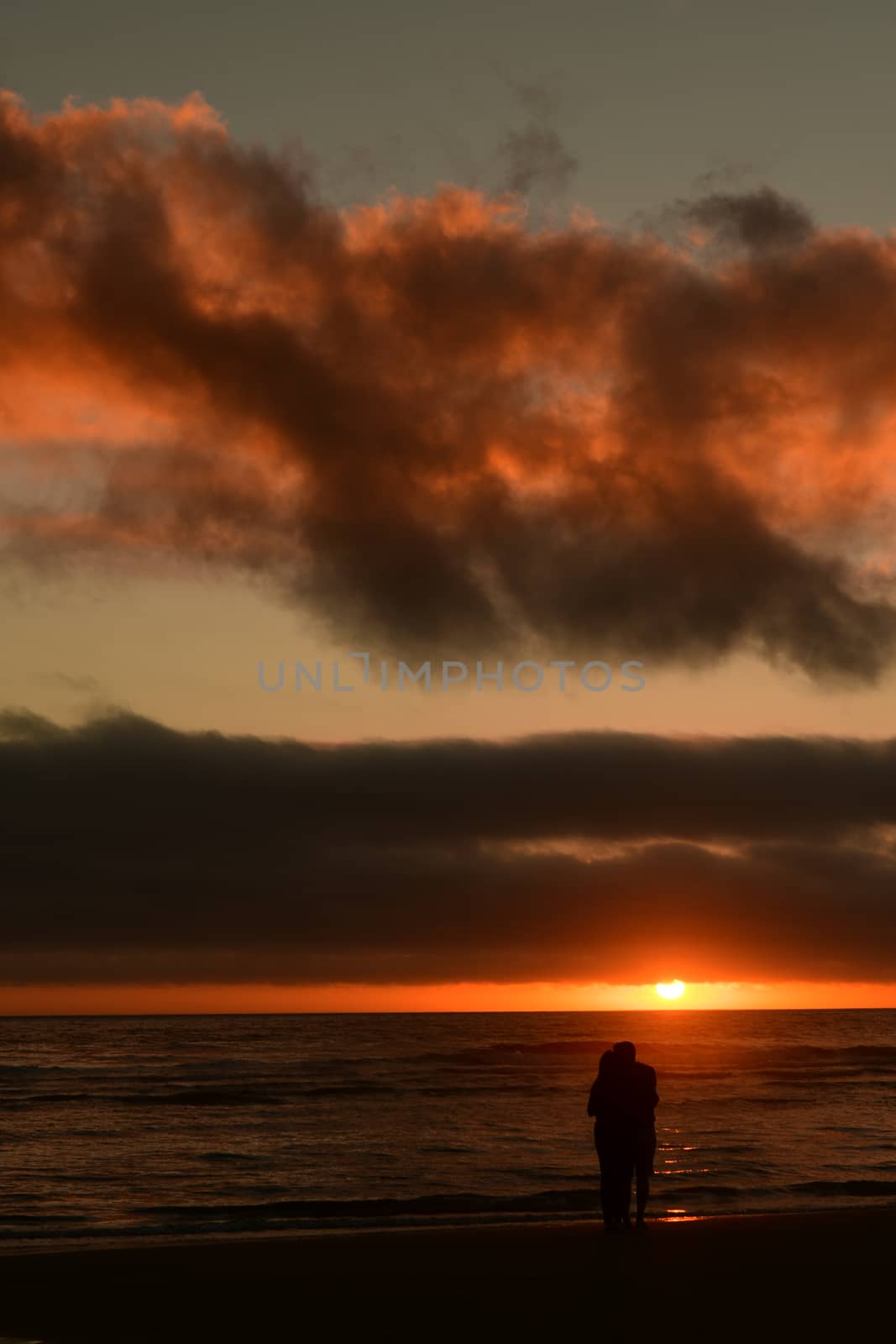 Couple enjoying a romantic sunset at Cannon Beach, Oregon.