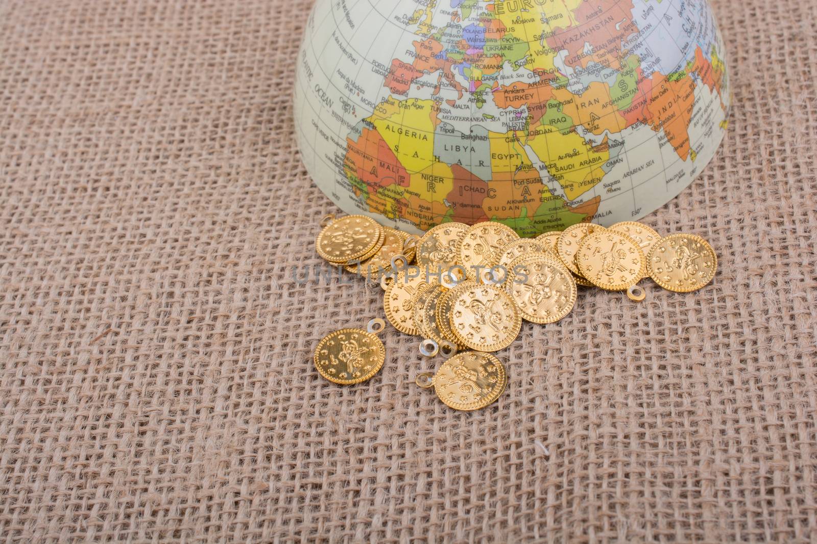 Fake gold coins  beside the globe by berkay