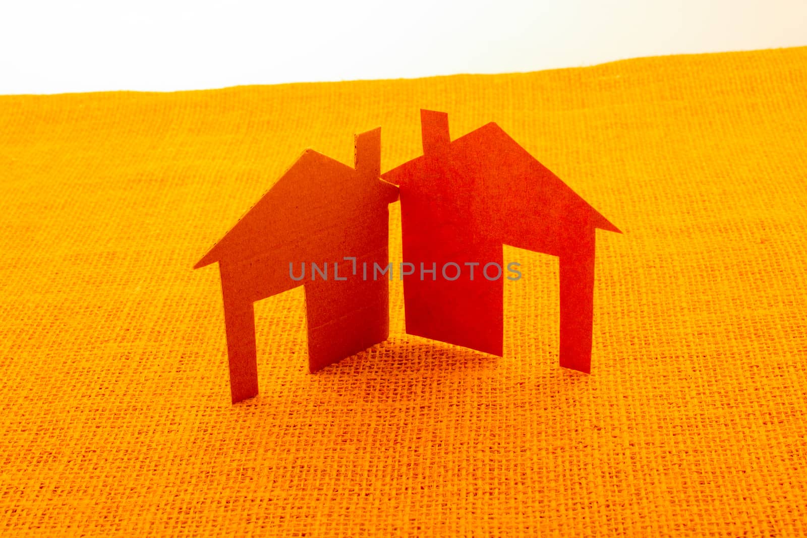 House shaped cut out of wood placed on a linen canvas