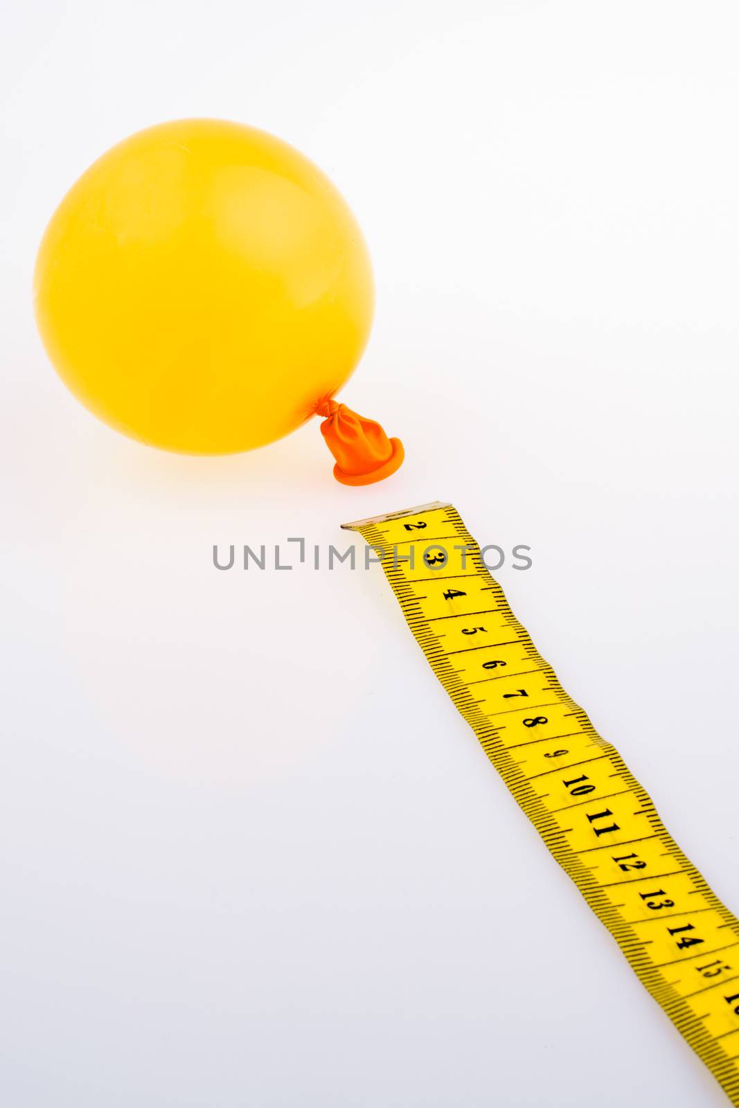 Yellow color measuring tape and a baloon by berkay