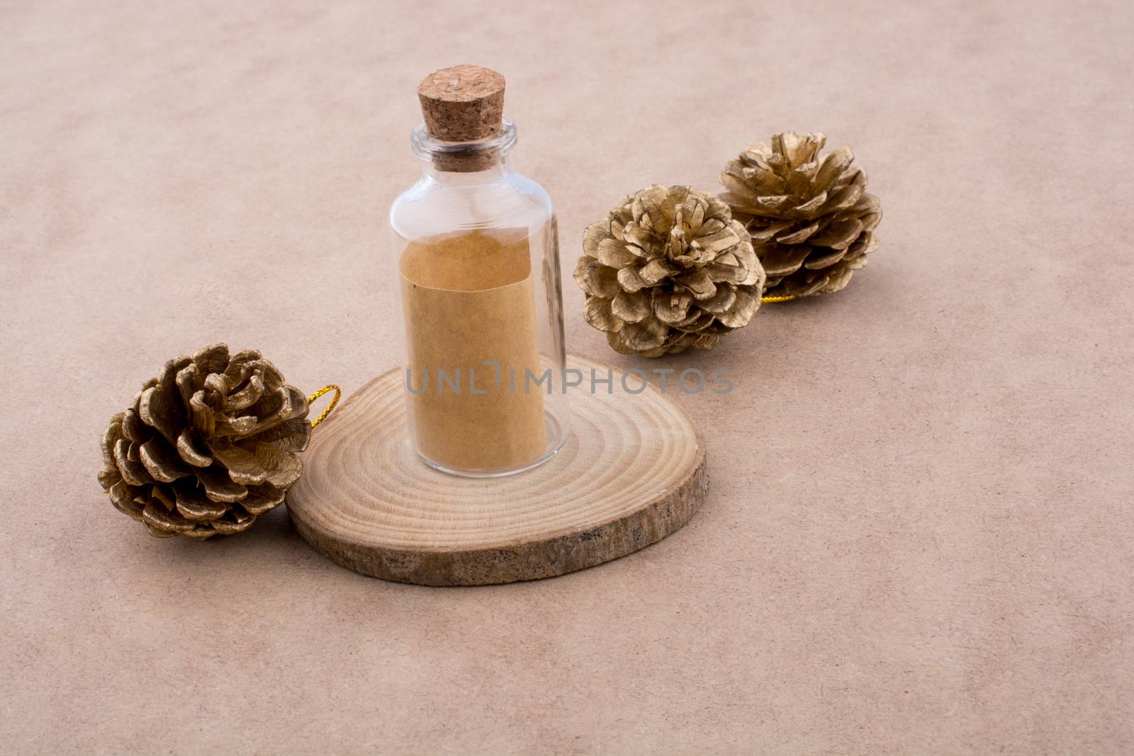 Pine cones and a bottle on a piece of cut wood by berkay
