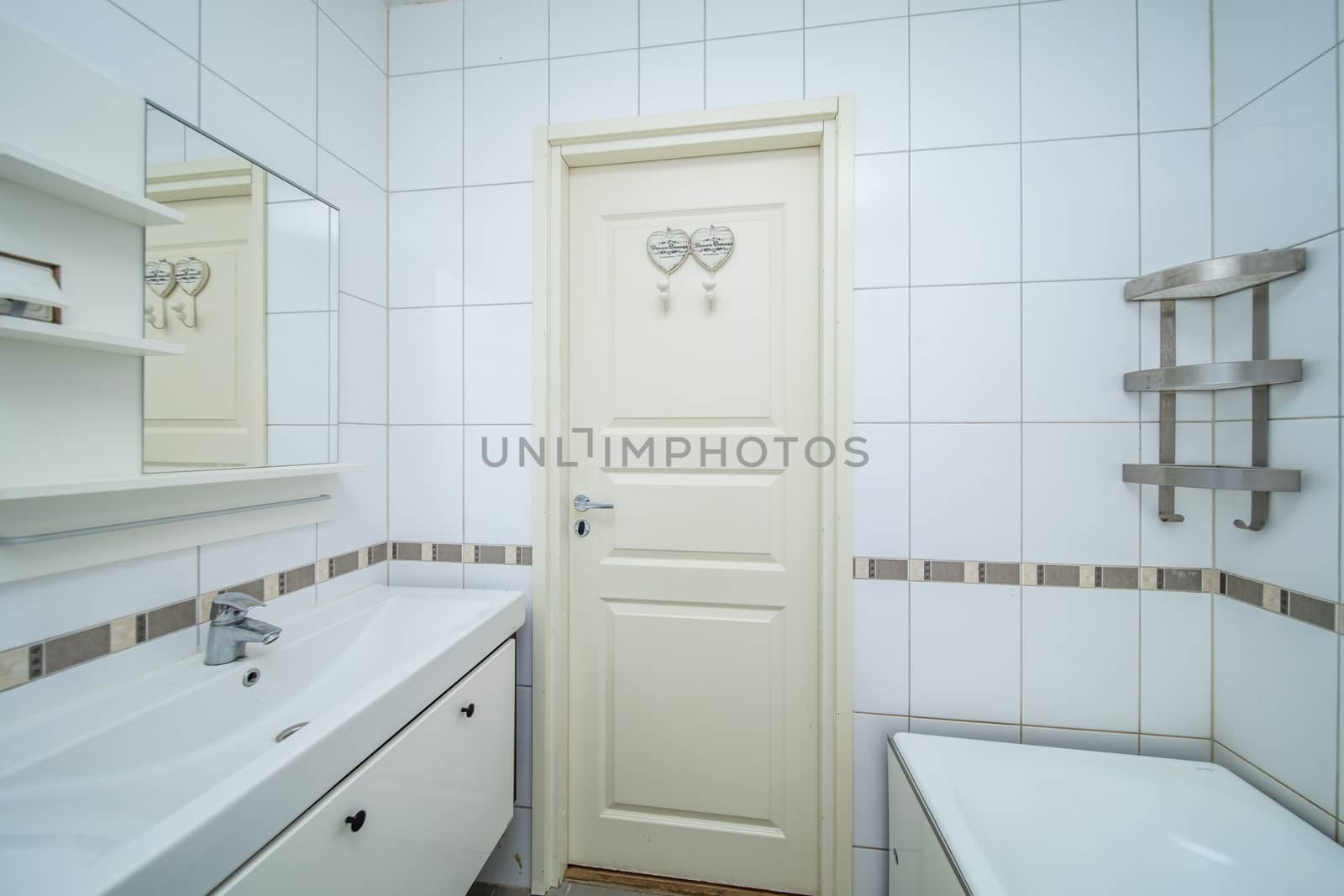 Small beige tile bathroom with bath tube and sink