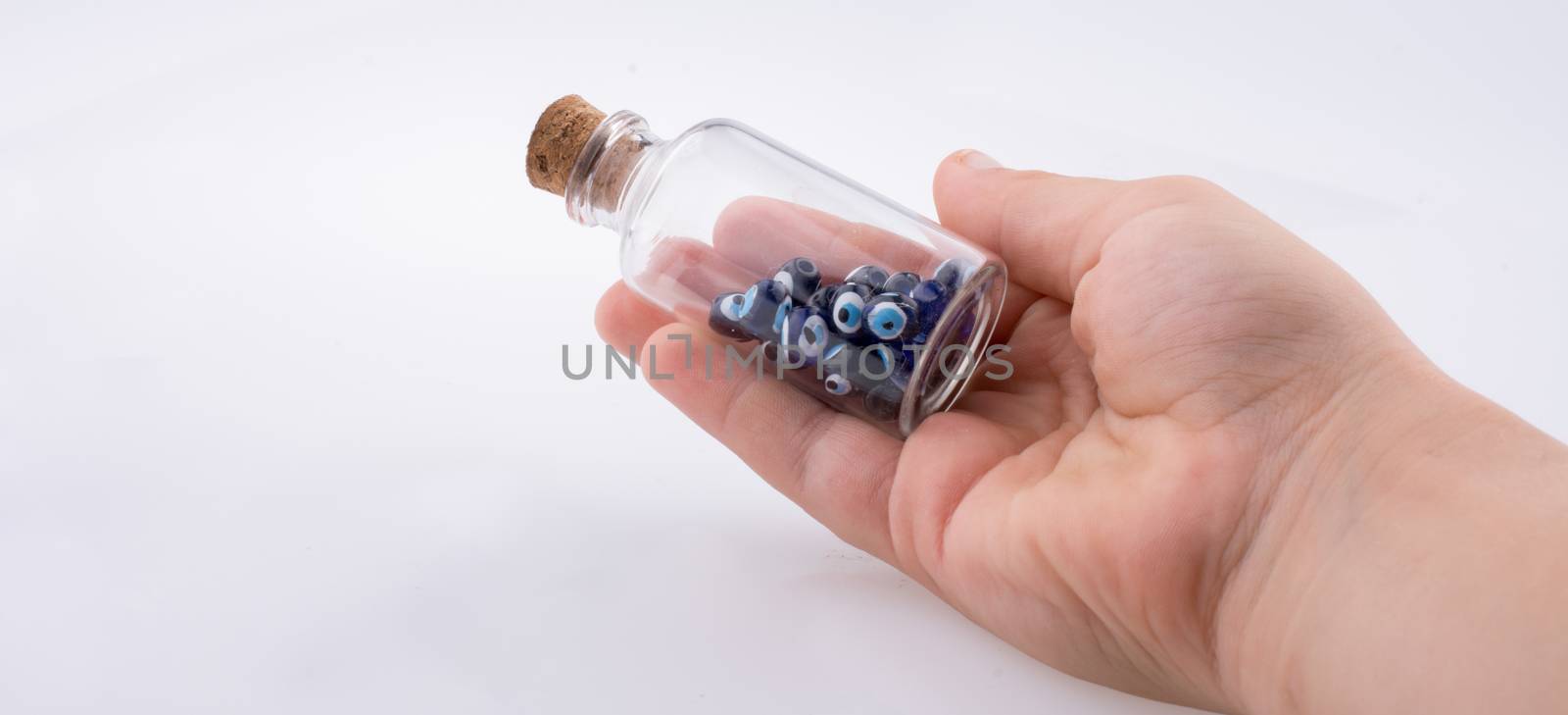 Little  glass bottle  with blue evil eye bead in hand