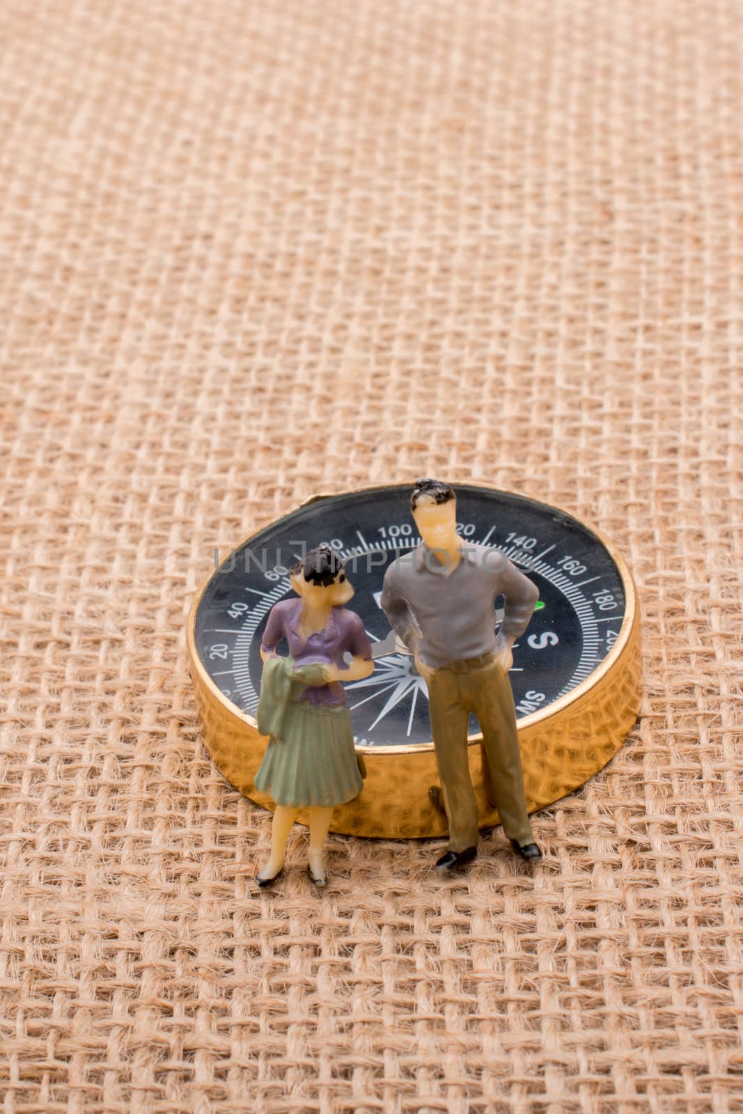 Man and woman figurine by the side of a compass by berkay