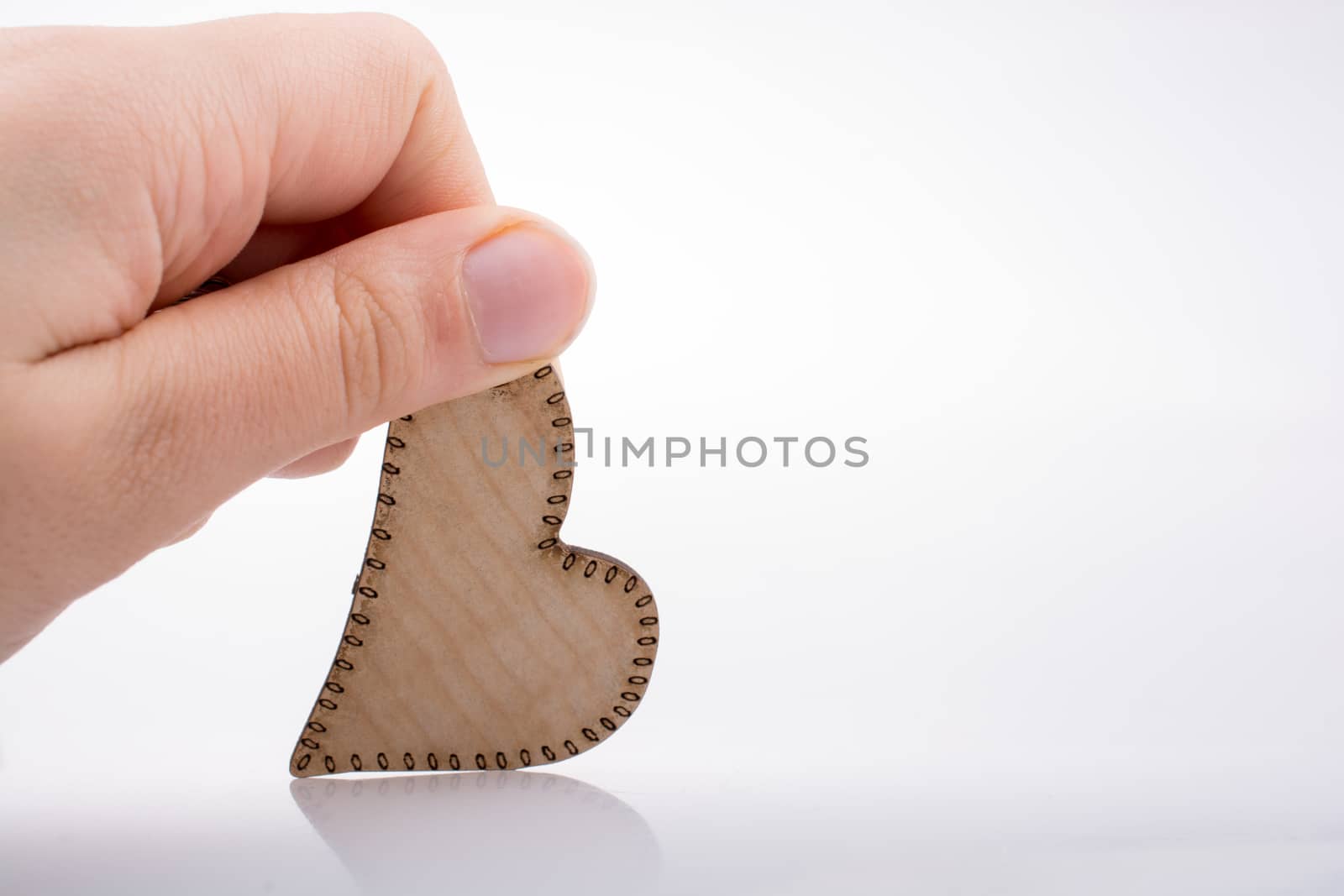 Heart shaped wooden object in the hand