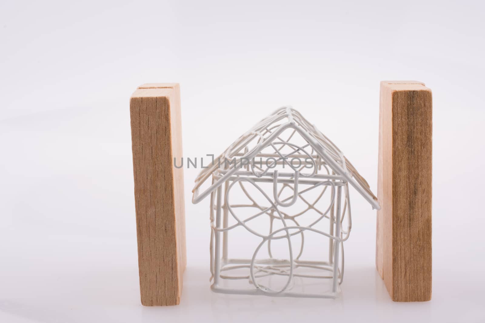 Little wired metal model house  between two domino pieces by berkay