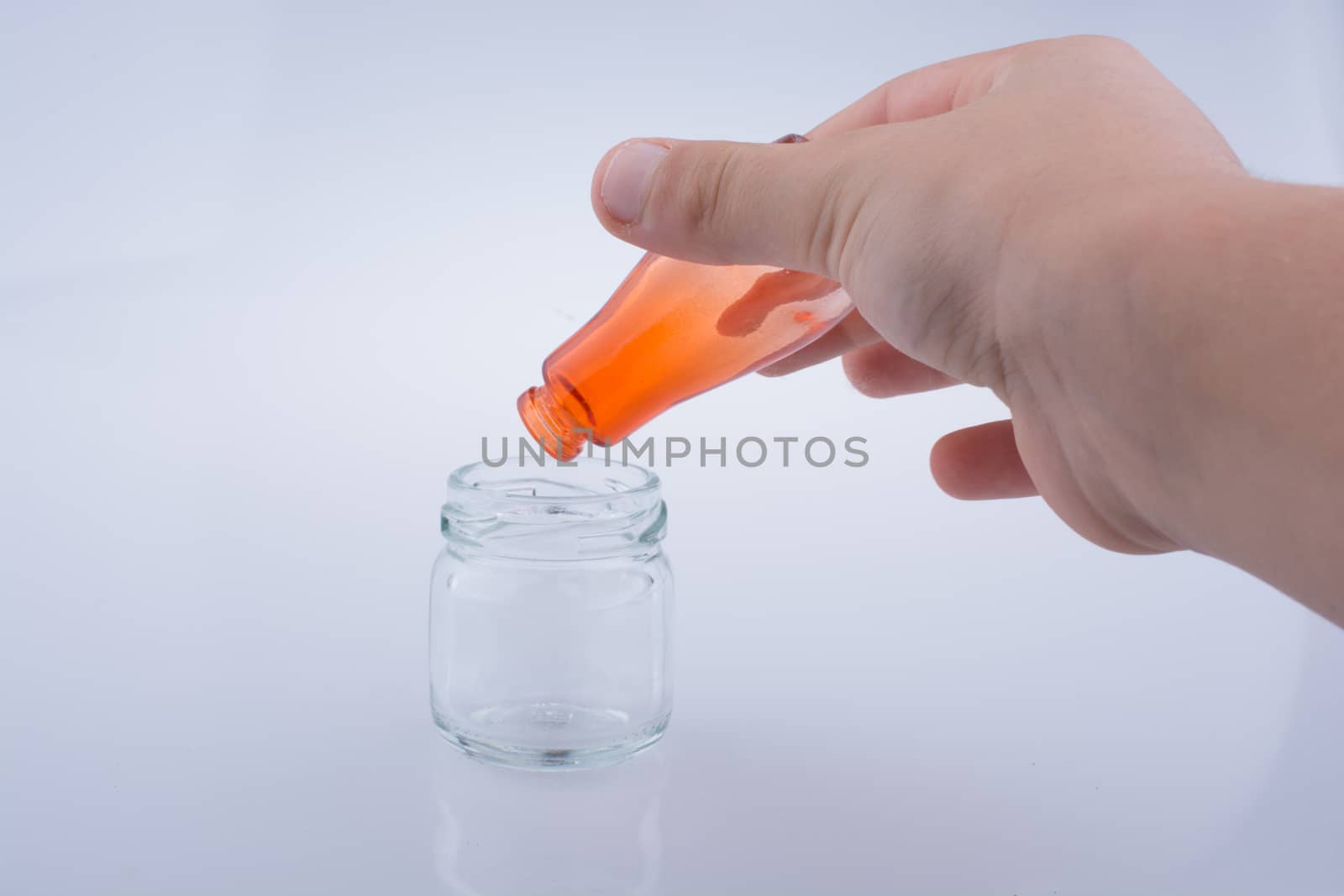 Little colorful  bottle over a jar on a white background
