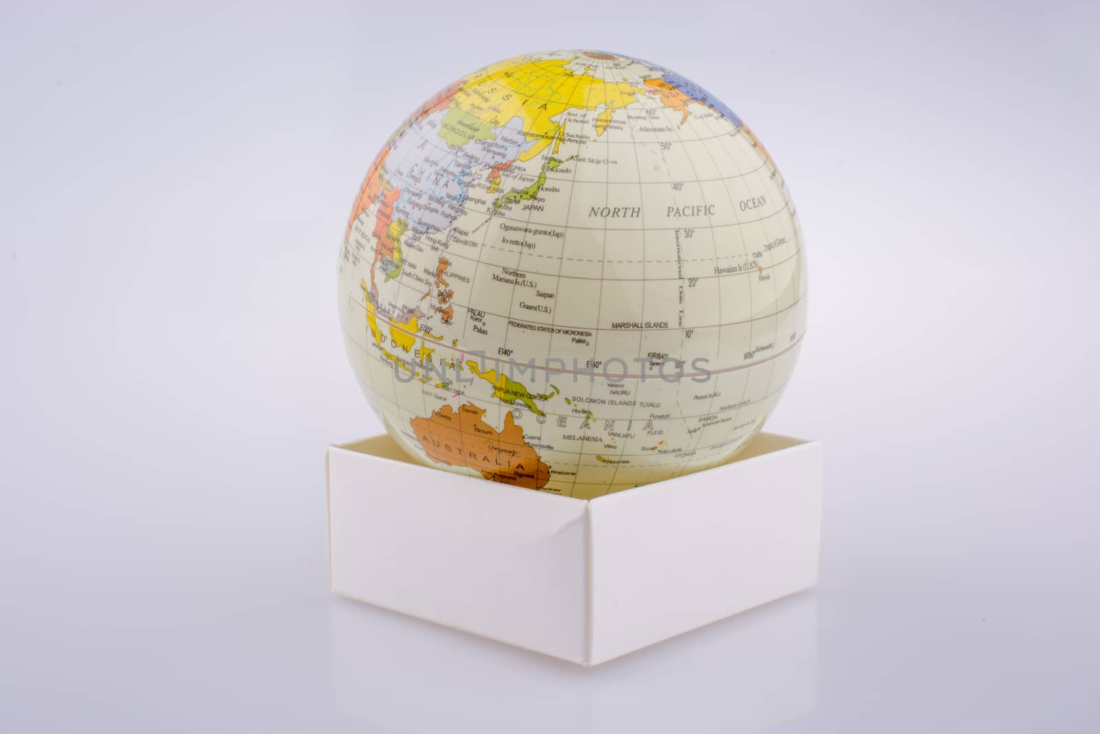 Little model globe put on a white box on a white background
