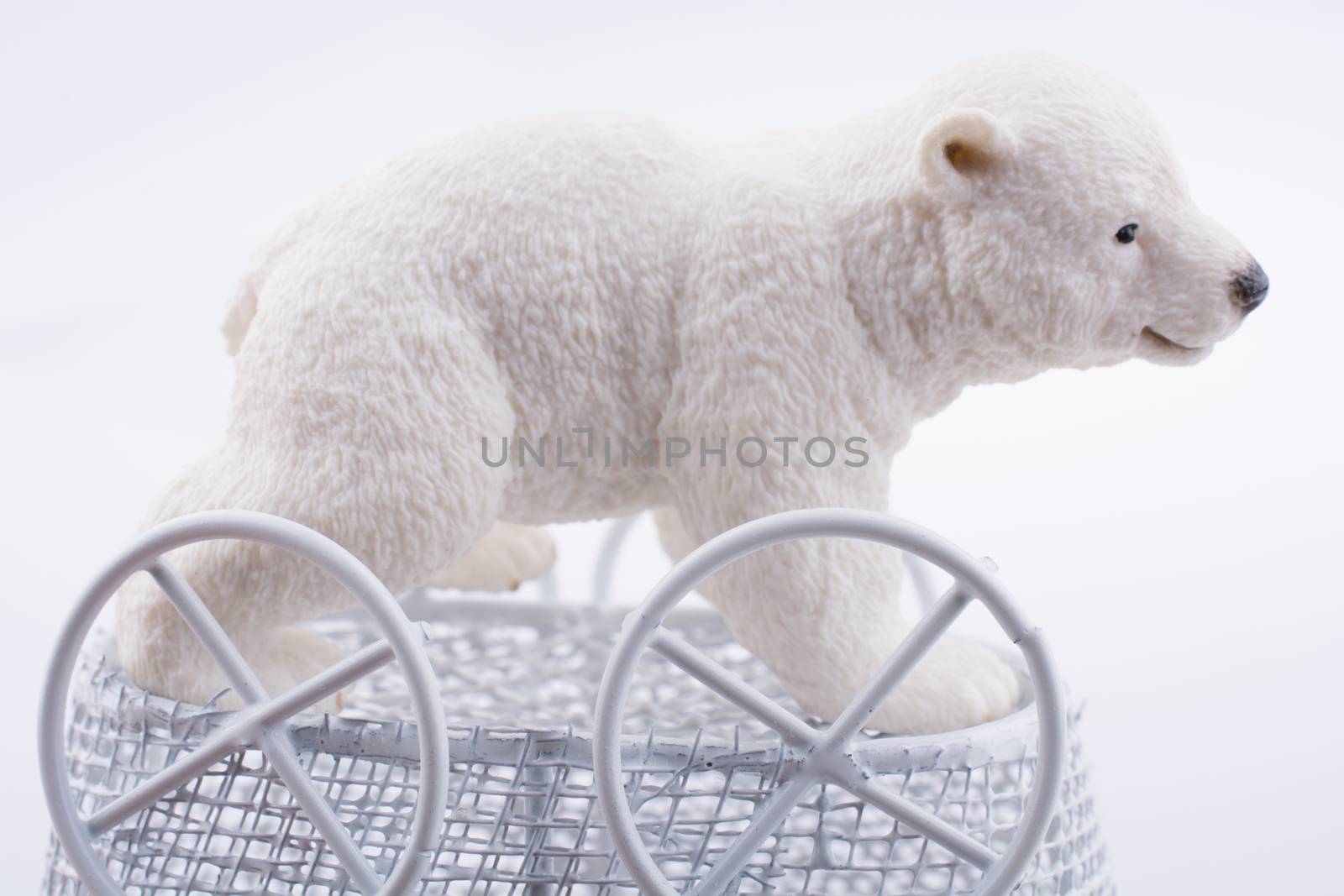 Little  Polar bear figure in a toy  baby carriage  made of metal on