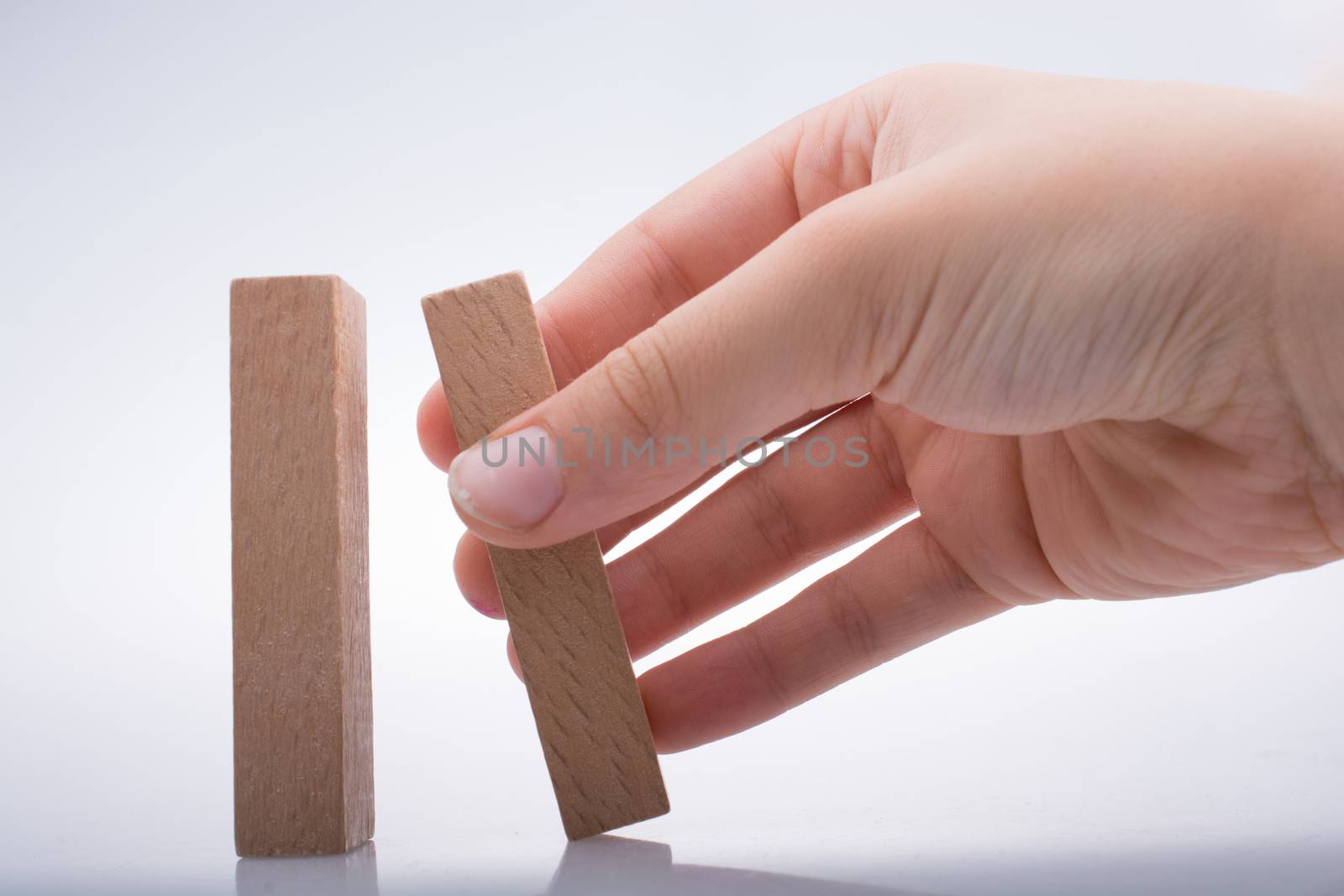 Hand holding wooden domino by berkay