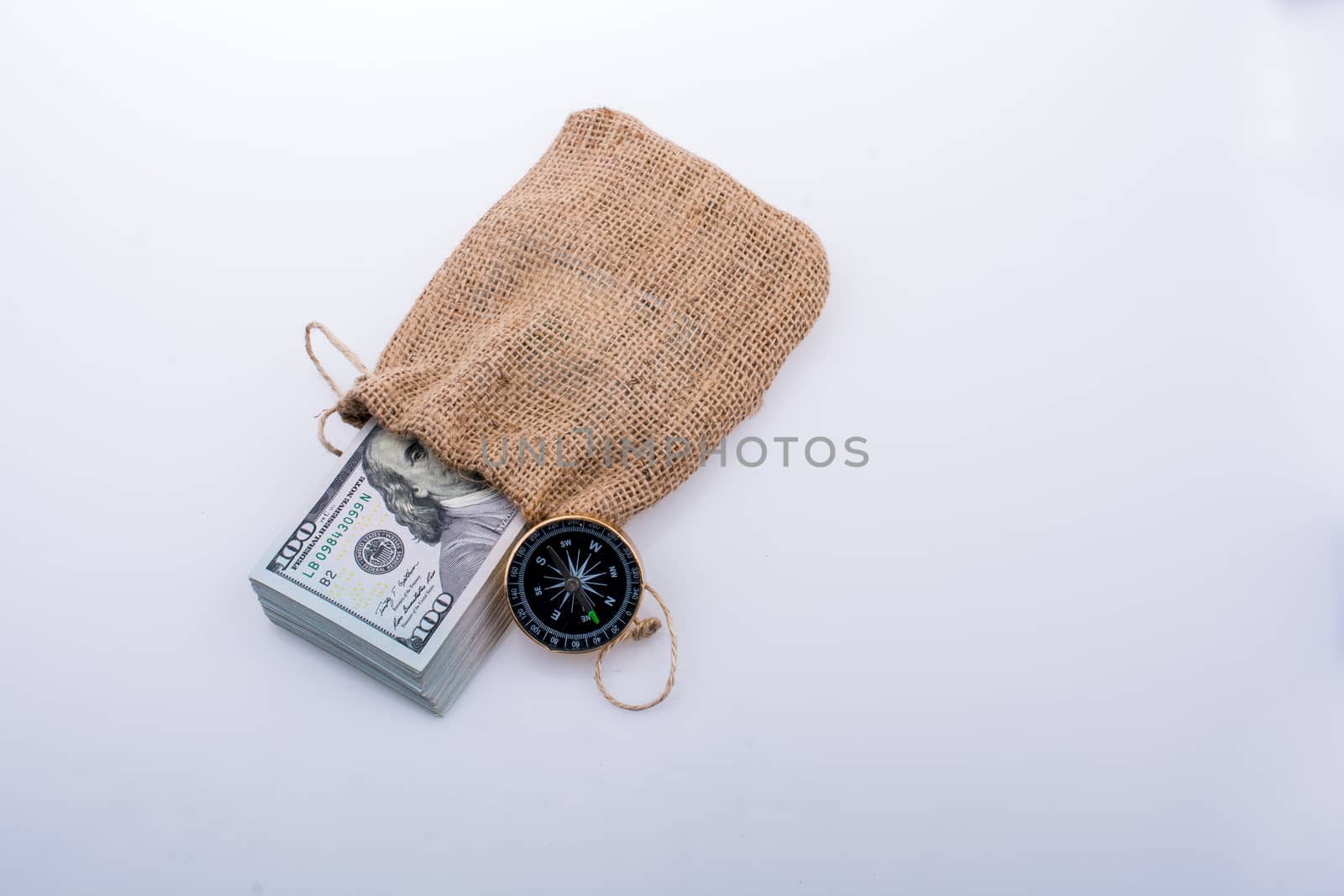 Compass and bundle of US dollarin a sack by berkay