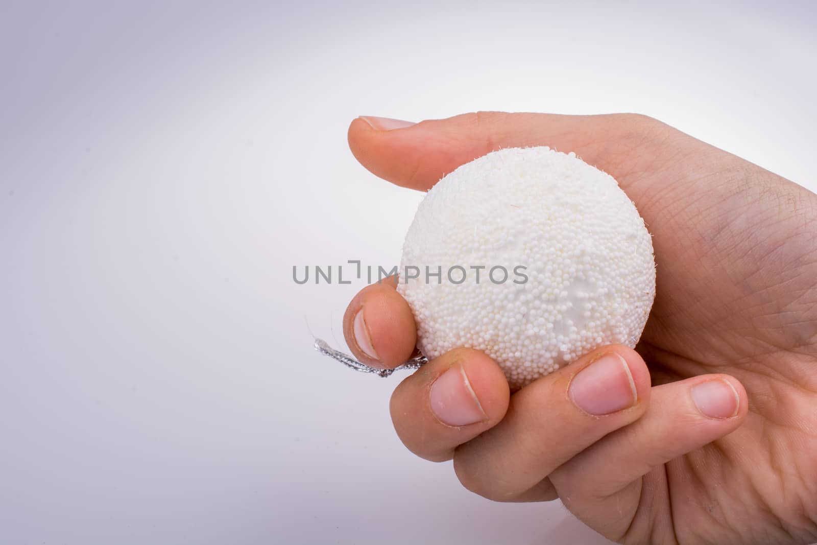 hand holding white color decorative ball in hand on white background