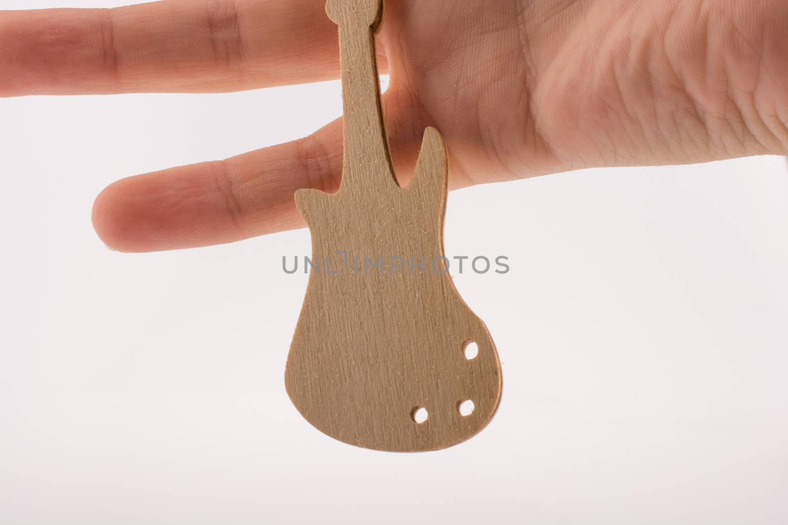 Mini wooden guitar model in hand by berkay