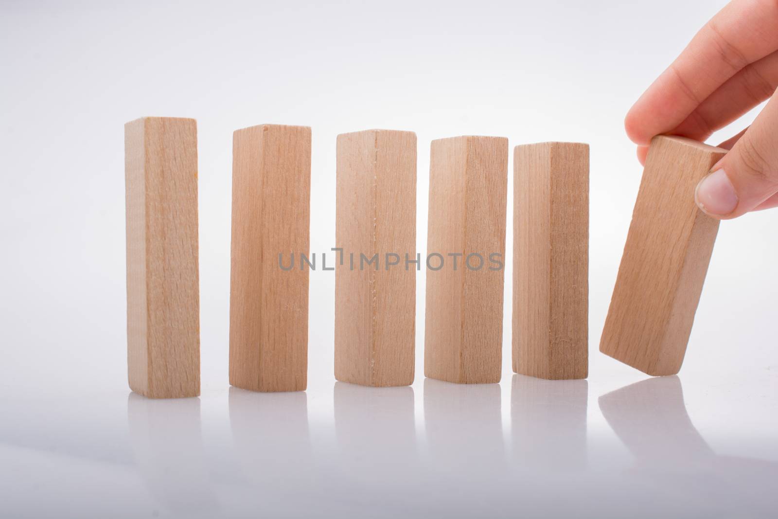 Hand holding wooden  domino on a white background