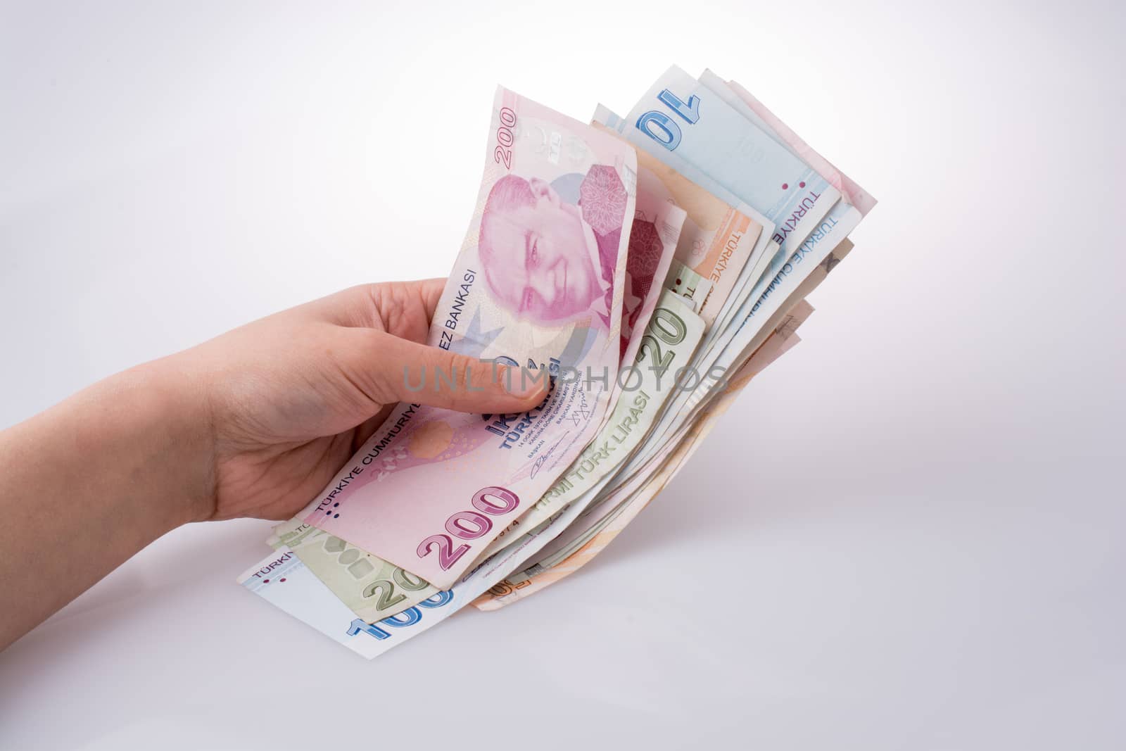 Hand holding Turksh Lira banknotes  on white background