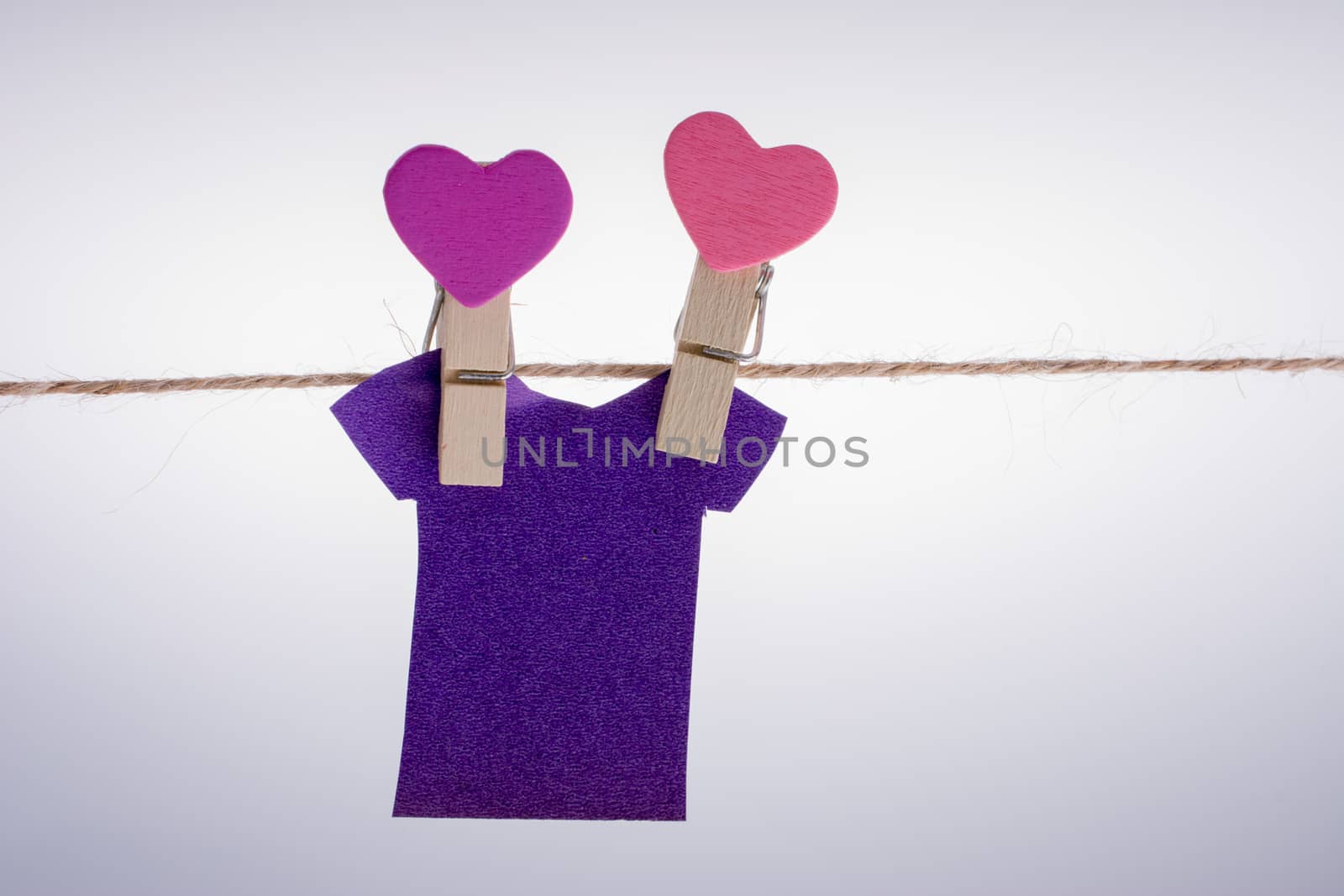 Paper clothes hang on a rope with clothespins by berkay