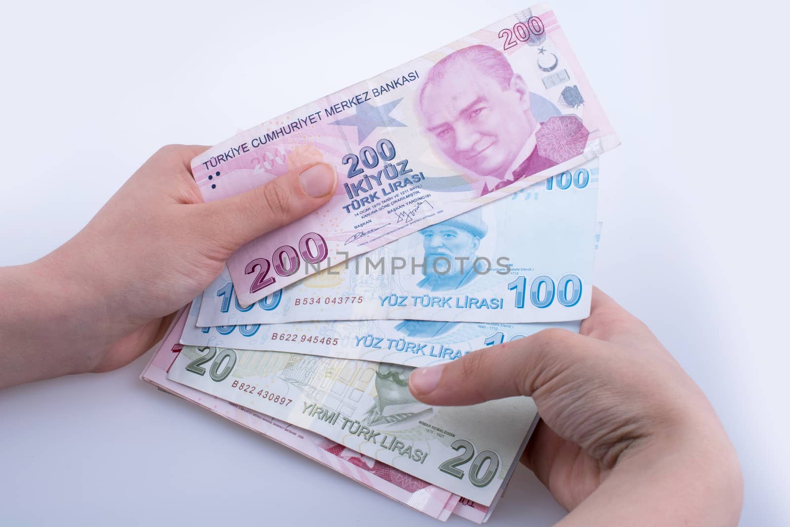 Hand holding Turksh Lira banknotes  on white background