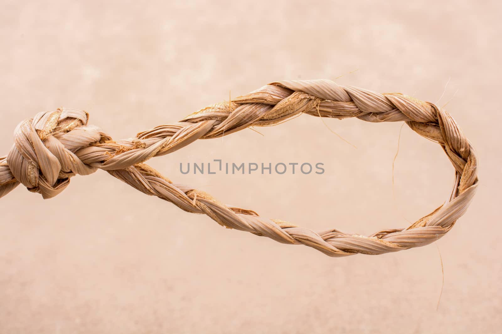 Straw tied  as knot on a light color background