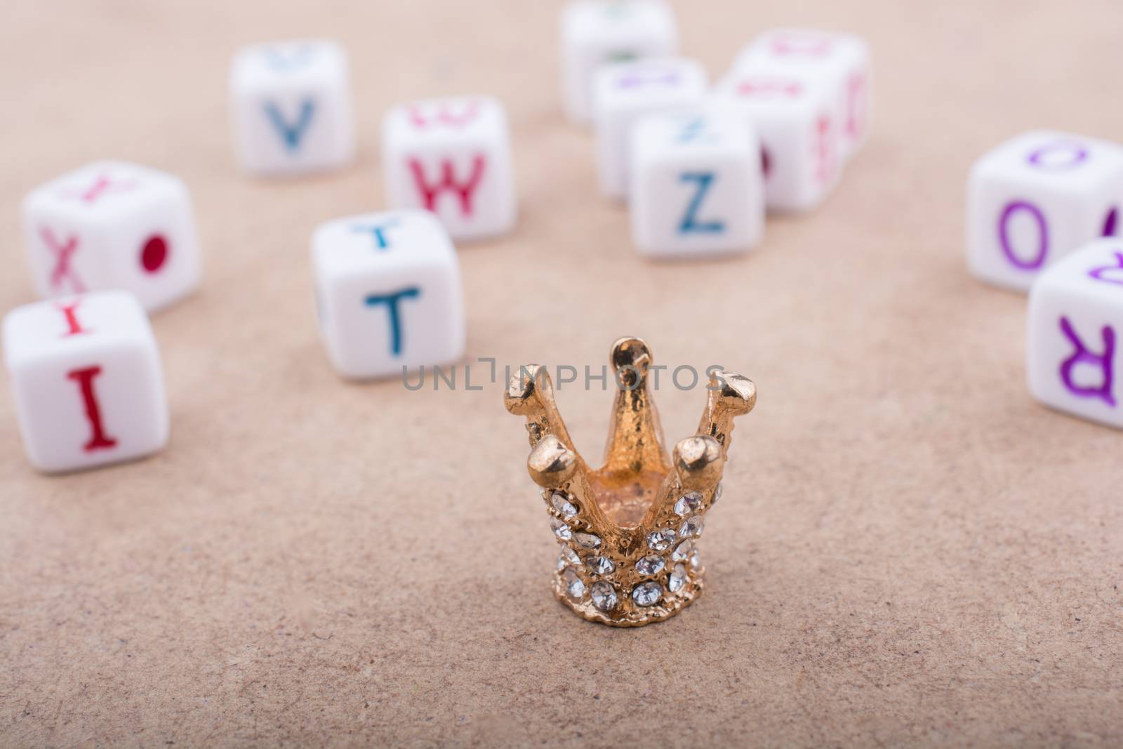 Golden color crown model in front of the letter cubes