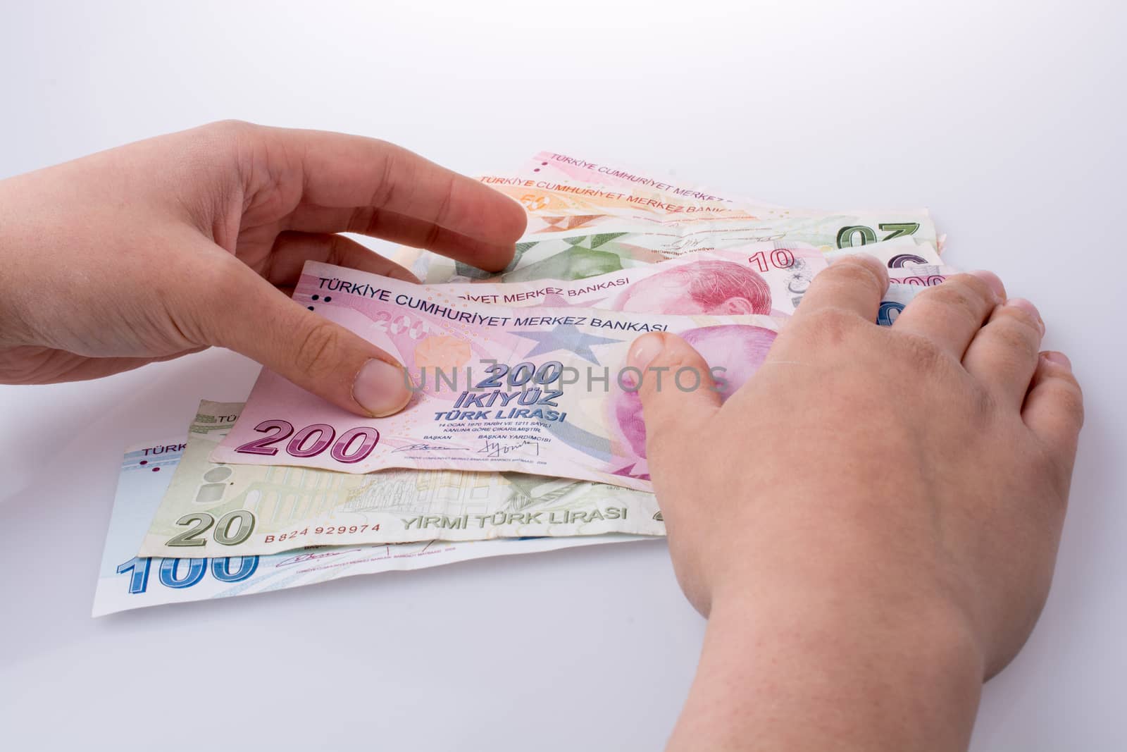 Hand holding Turksh Lira banknotes  on white background