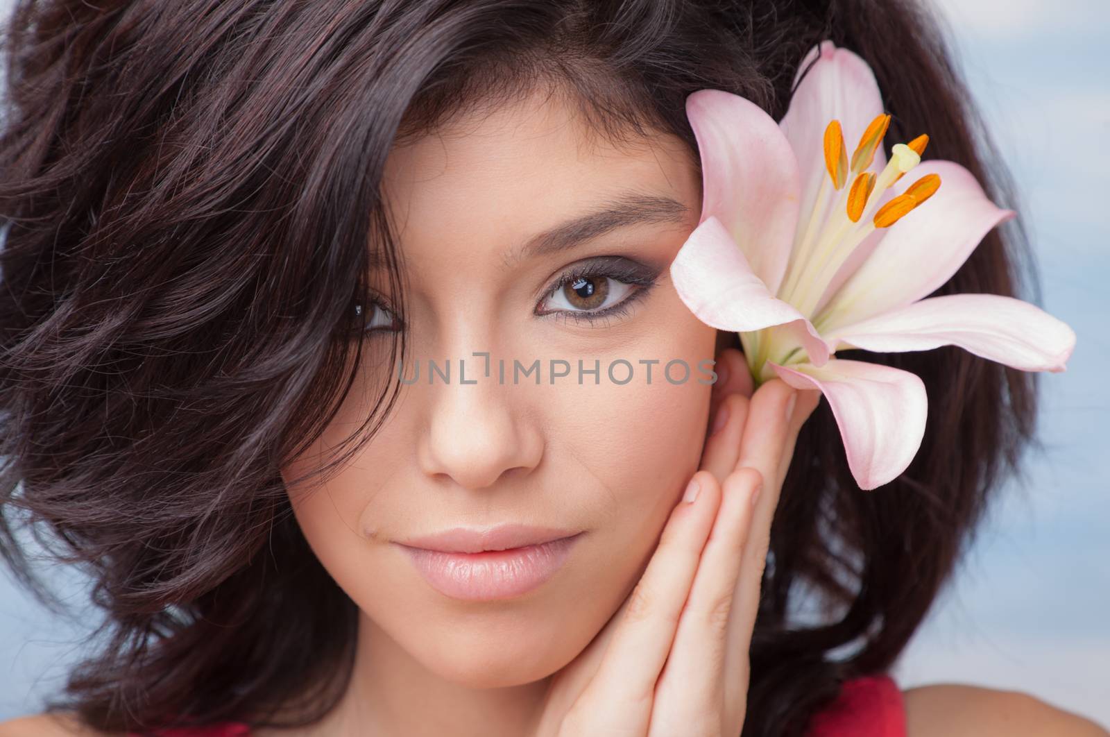 Portrait of a young beautiful girl with Lilium in her hair.