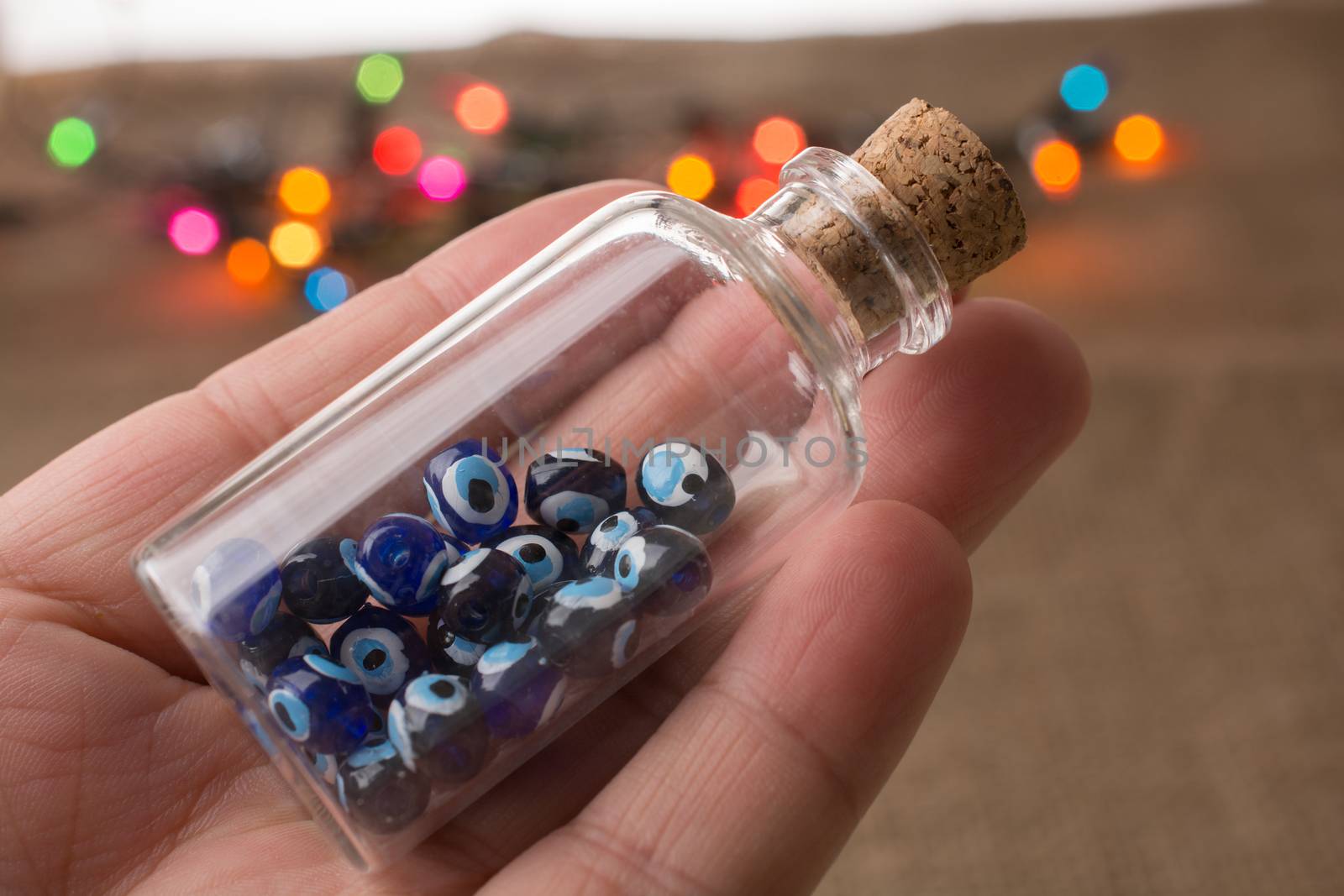 Hand holding Evil eye bead in bottle as  souvenir