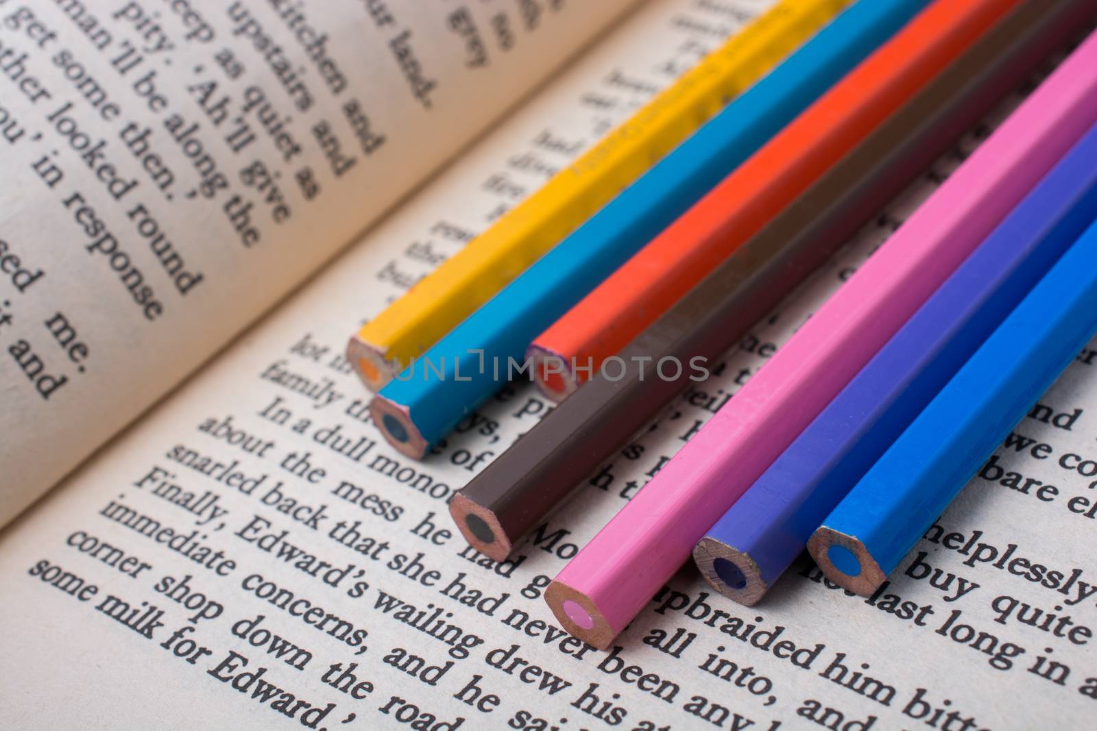 Color pencils placed on the page of a book with text