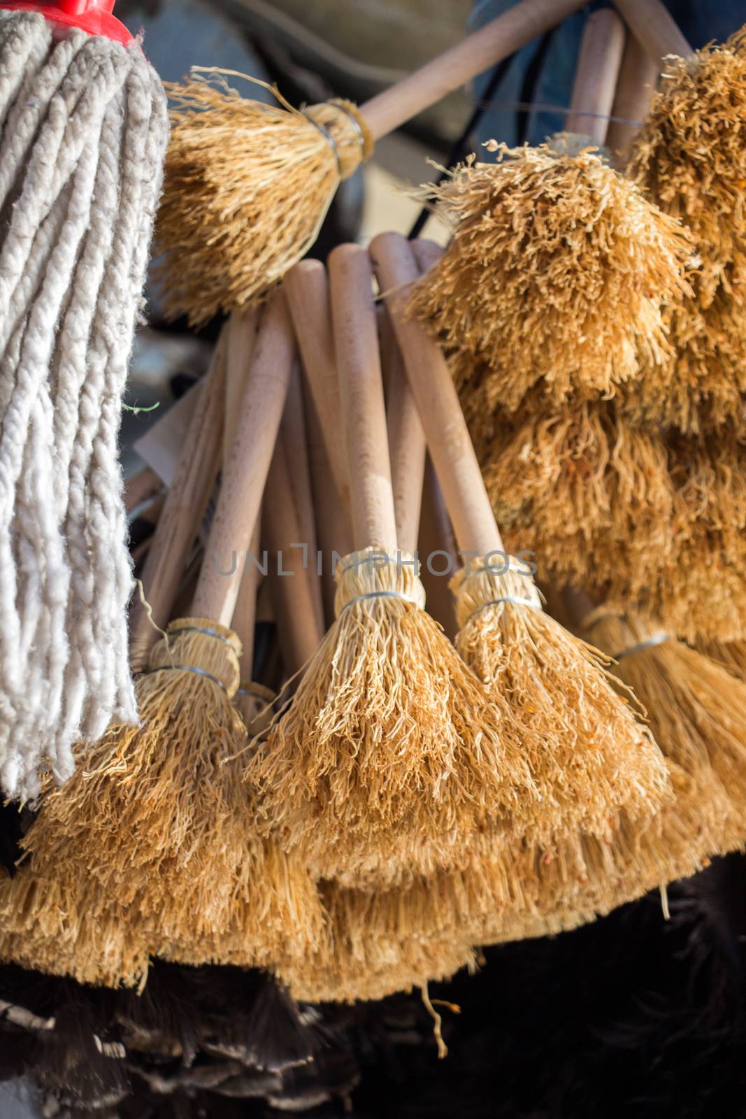 Set of yellow straw broom in a bazaar