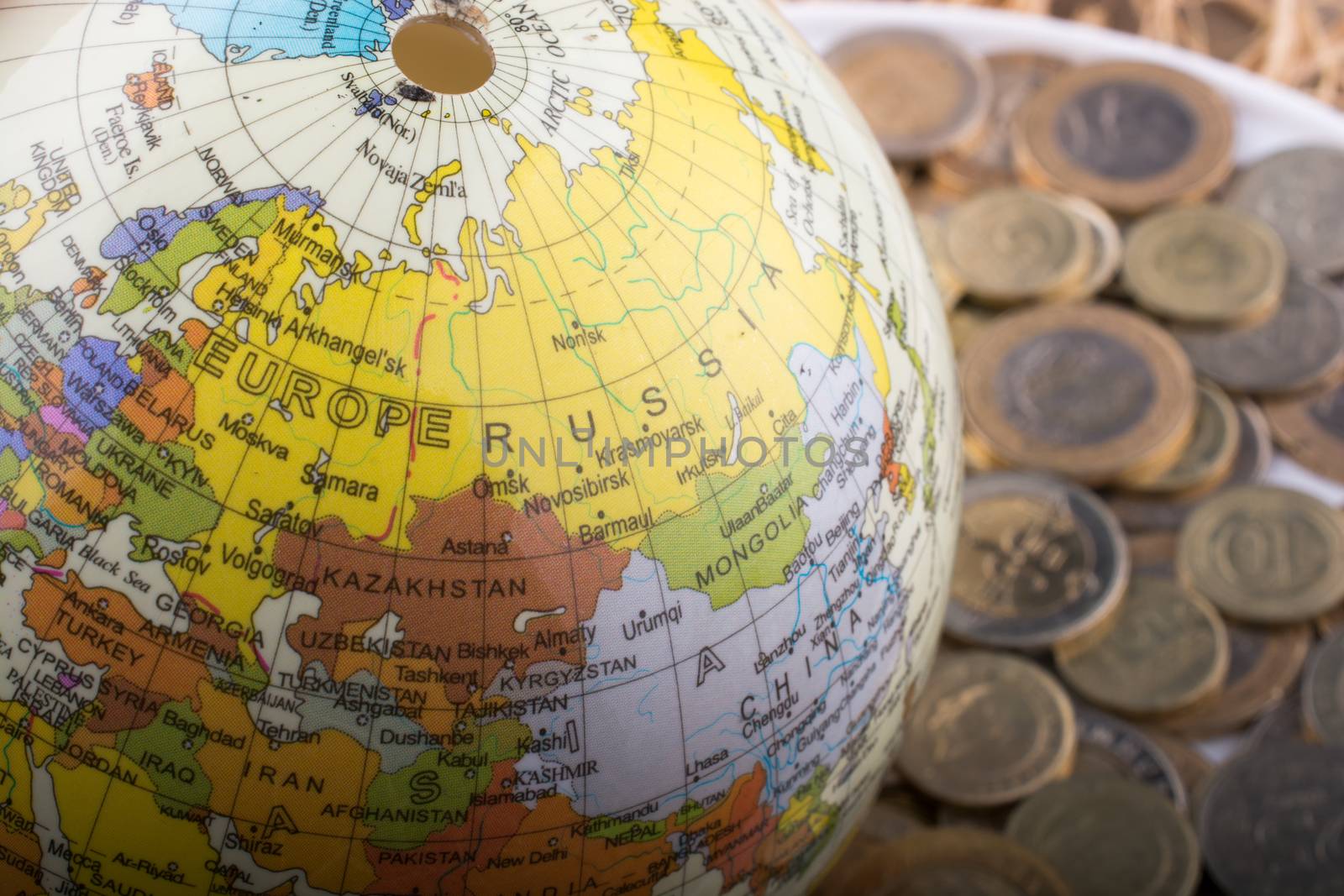 Turkish Lira coins by the side of a model globe on white background