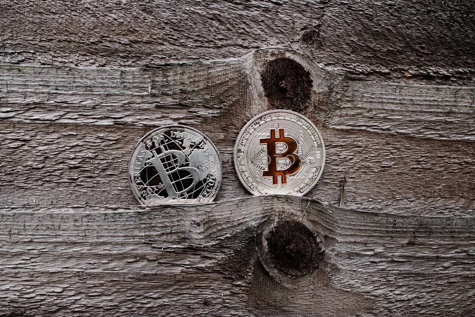 Digital currency physical silver bitcoin coins on the wooden background.