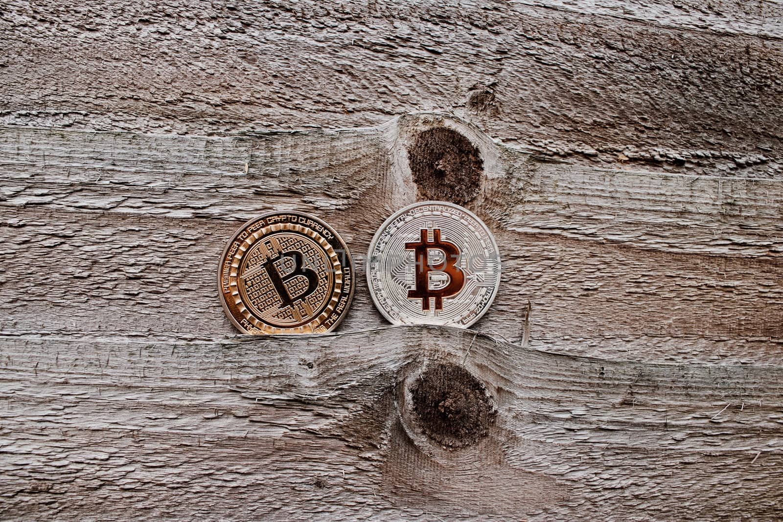 Digital currency physical gold and silver bitcoin coin on the wooden background.