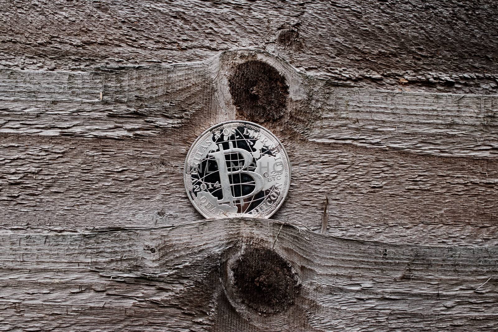Digital currency physical silver bitcoin coin on the wooden background.