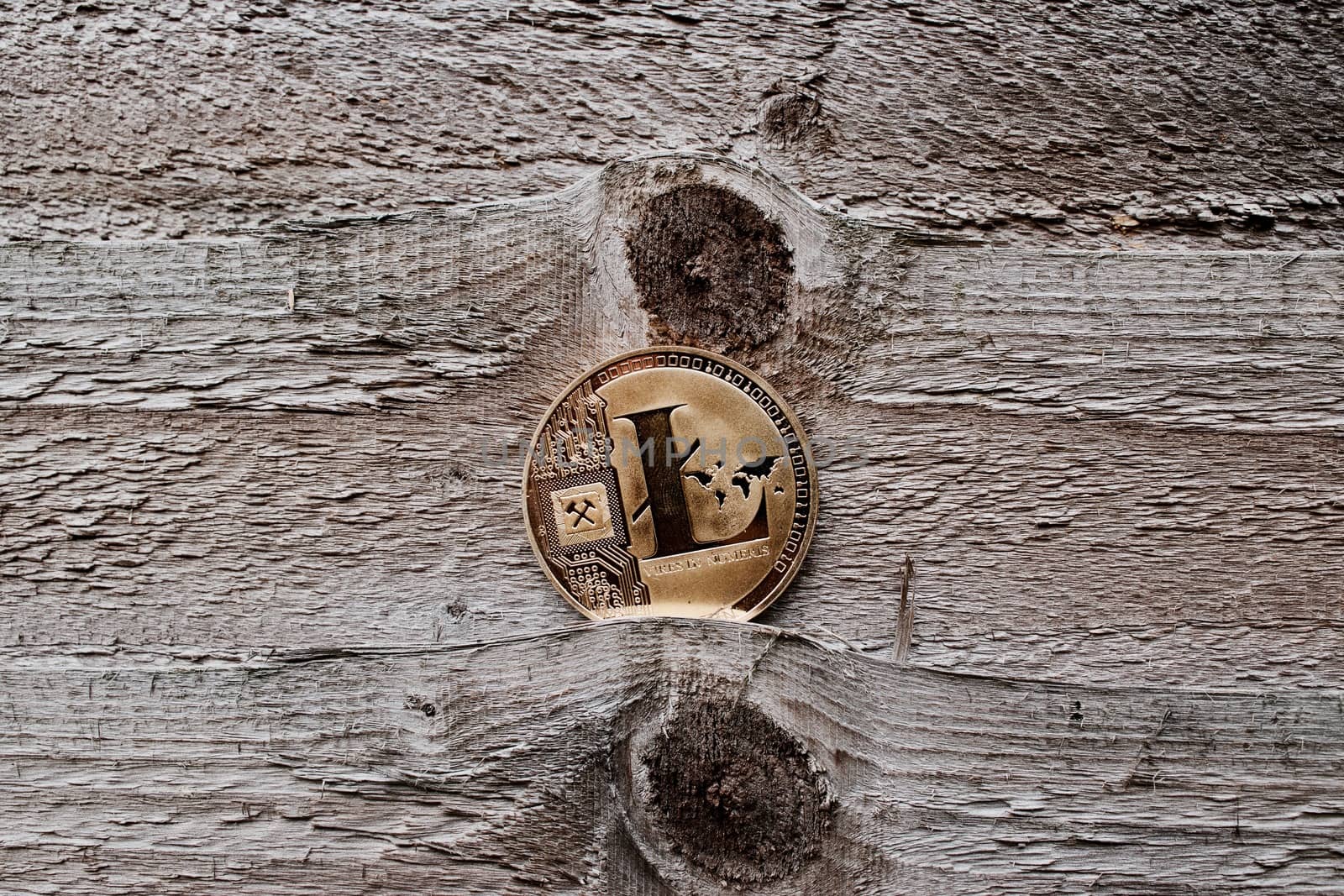 Digital currency physical gold litecoin coin on the wooden background.