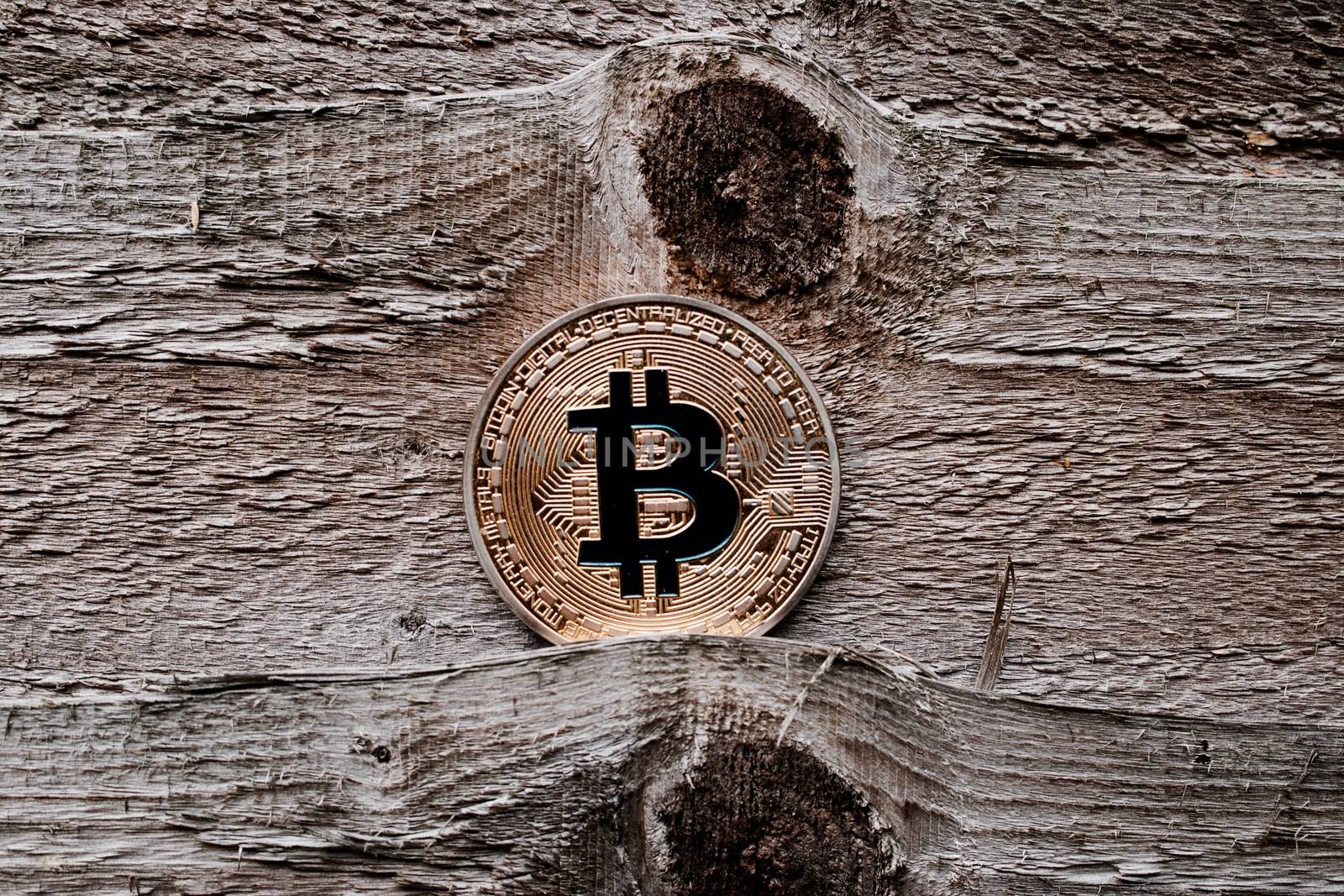 Digital currency physical gold bitcoin coin on the wooden background.