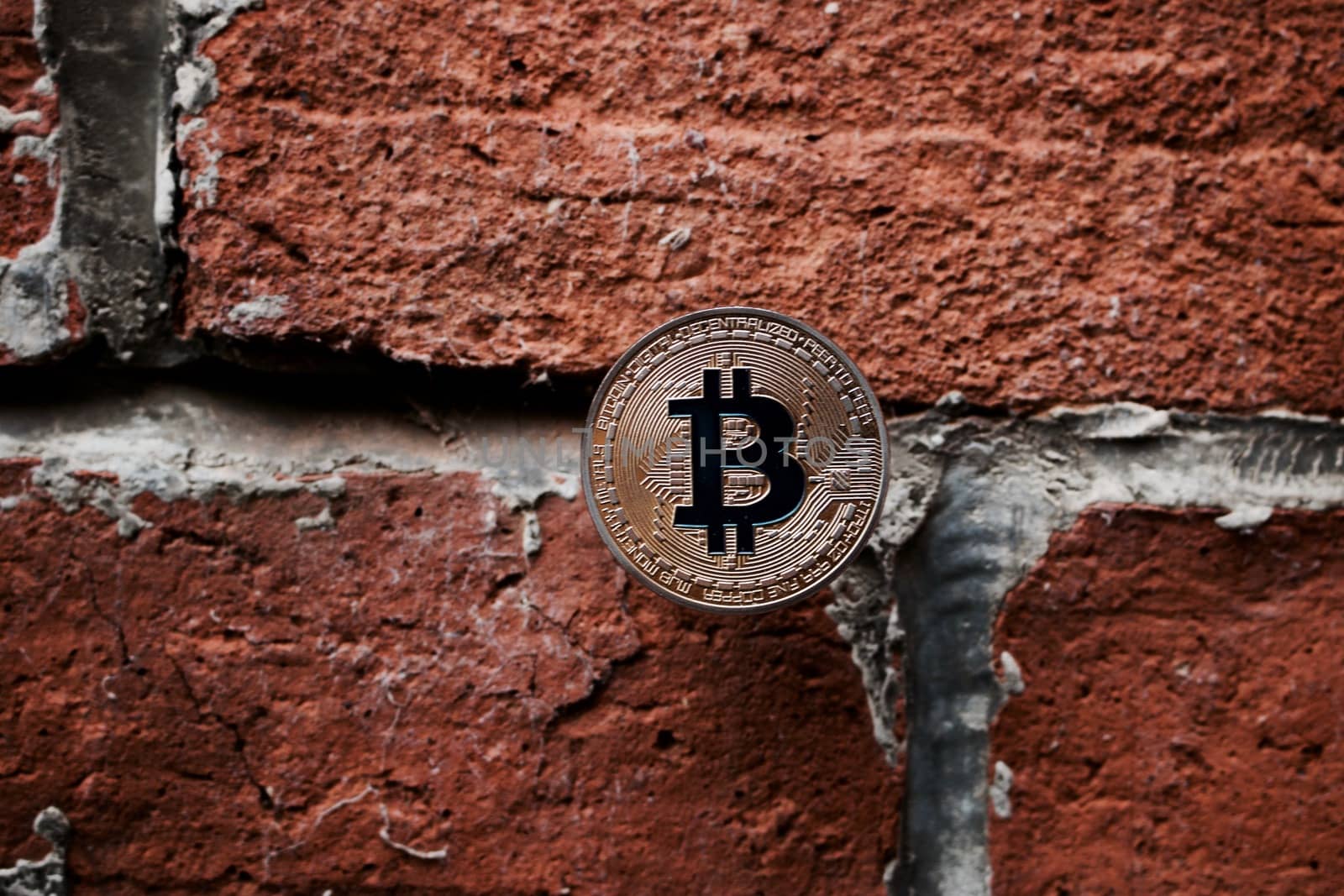 Digital currency physical gold bitcoin coin on the brick wall.