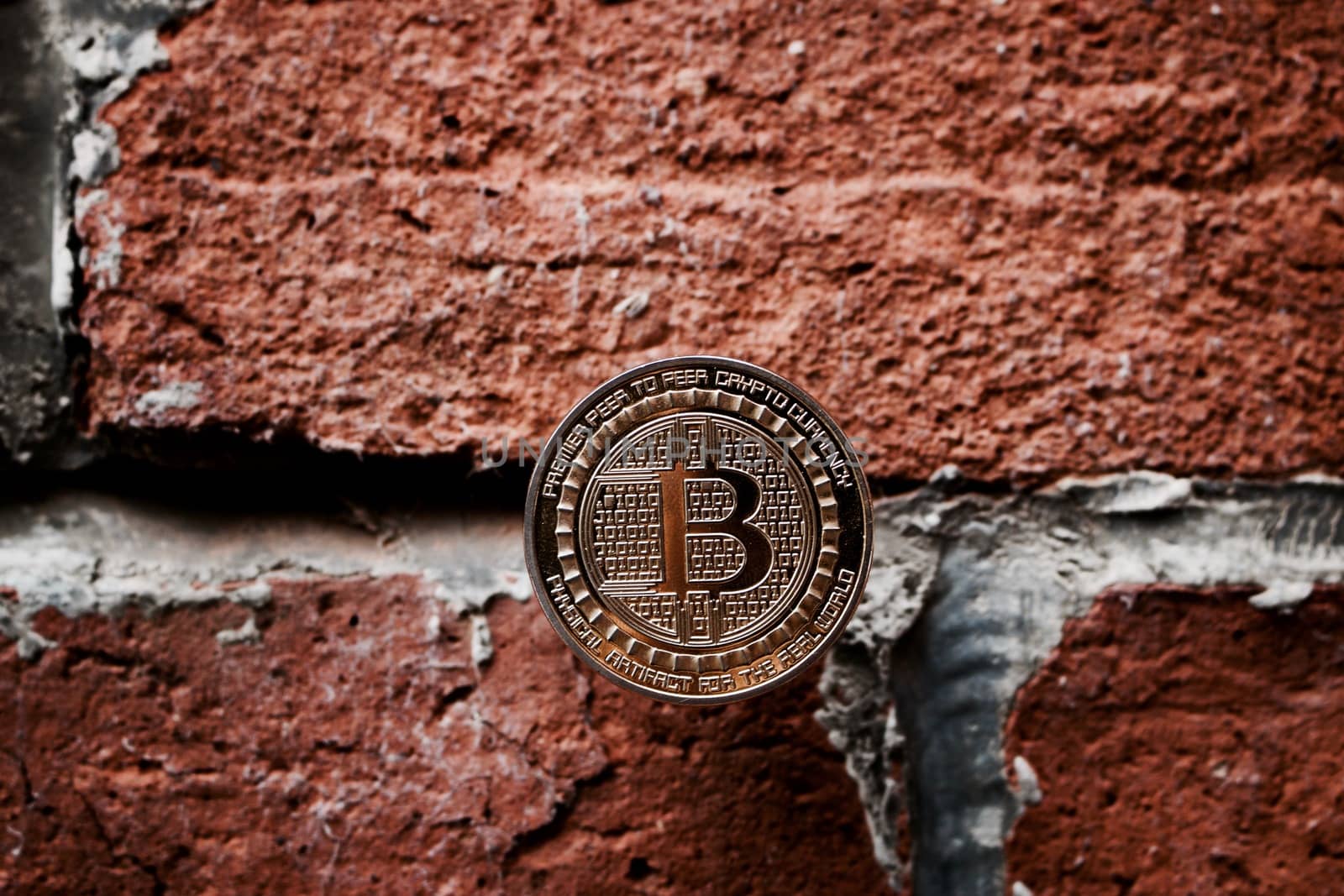 Digital currency physical gold bitcoin coin on the brick wall.