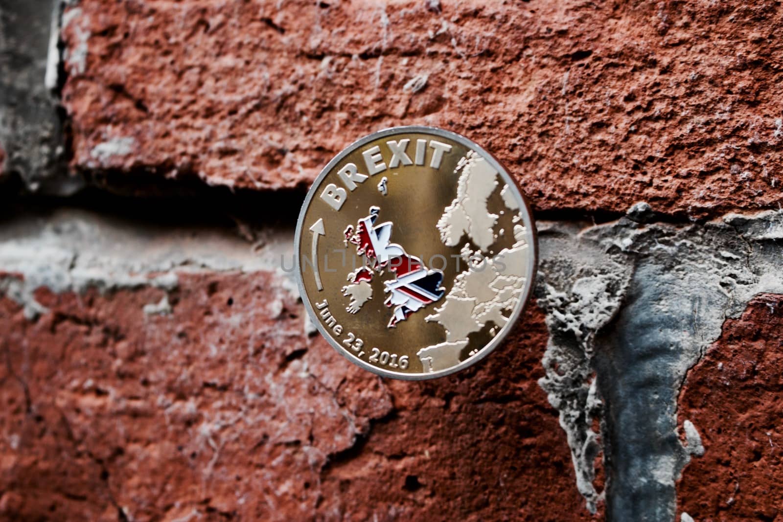 Europe leaving. Gold brexit coin on the brick wall with british map. June 23.
