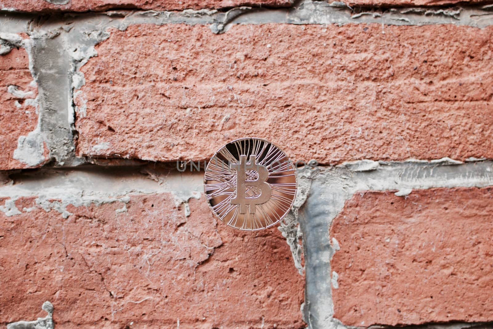 Digital currency physical gold bitcoin coin on brick wall. Business concept.