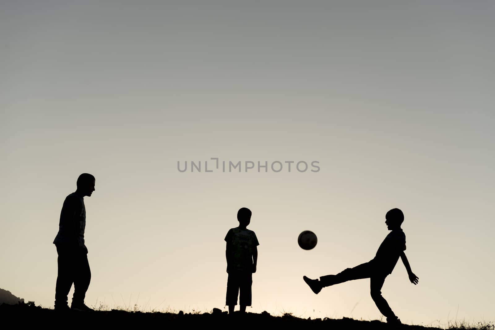 Children playing soccer in the nature