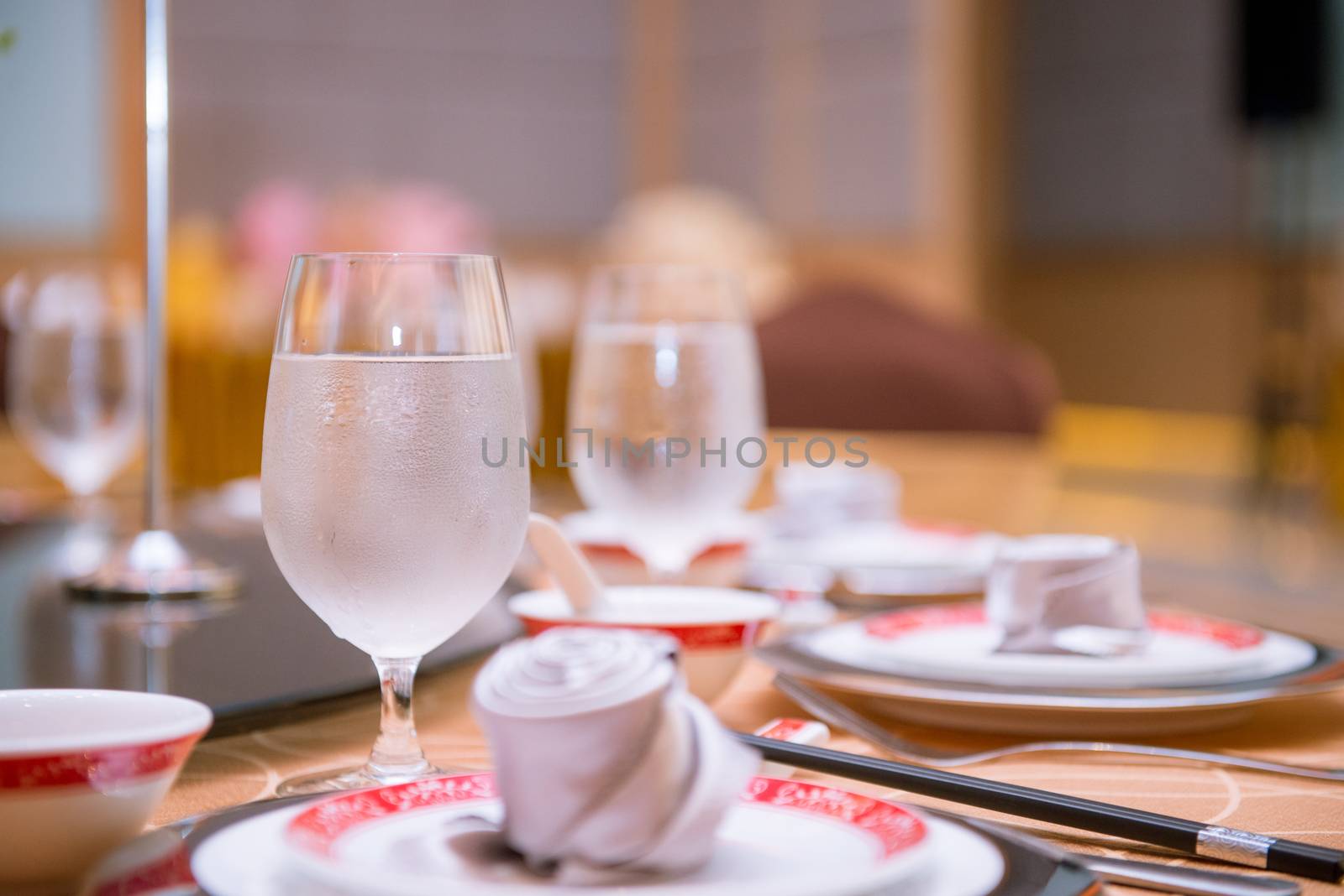 cool water glass on dining table in chinese restaurant by antpkr
