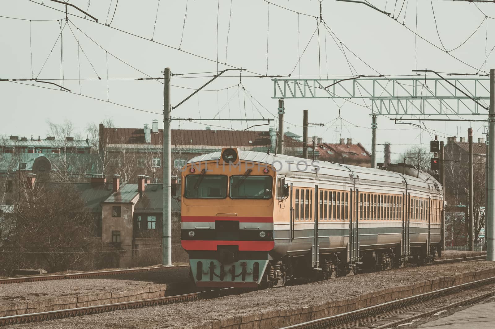 Old yellow passenger diesel train moving at the terminal