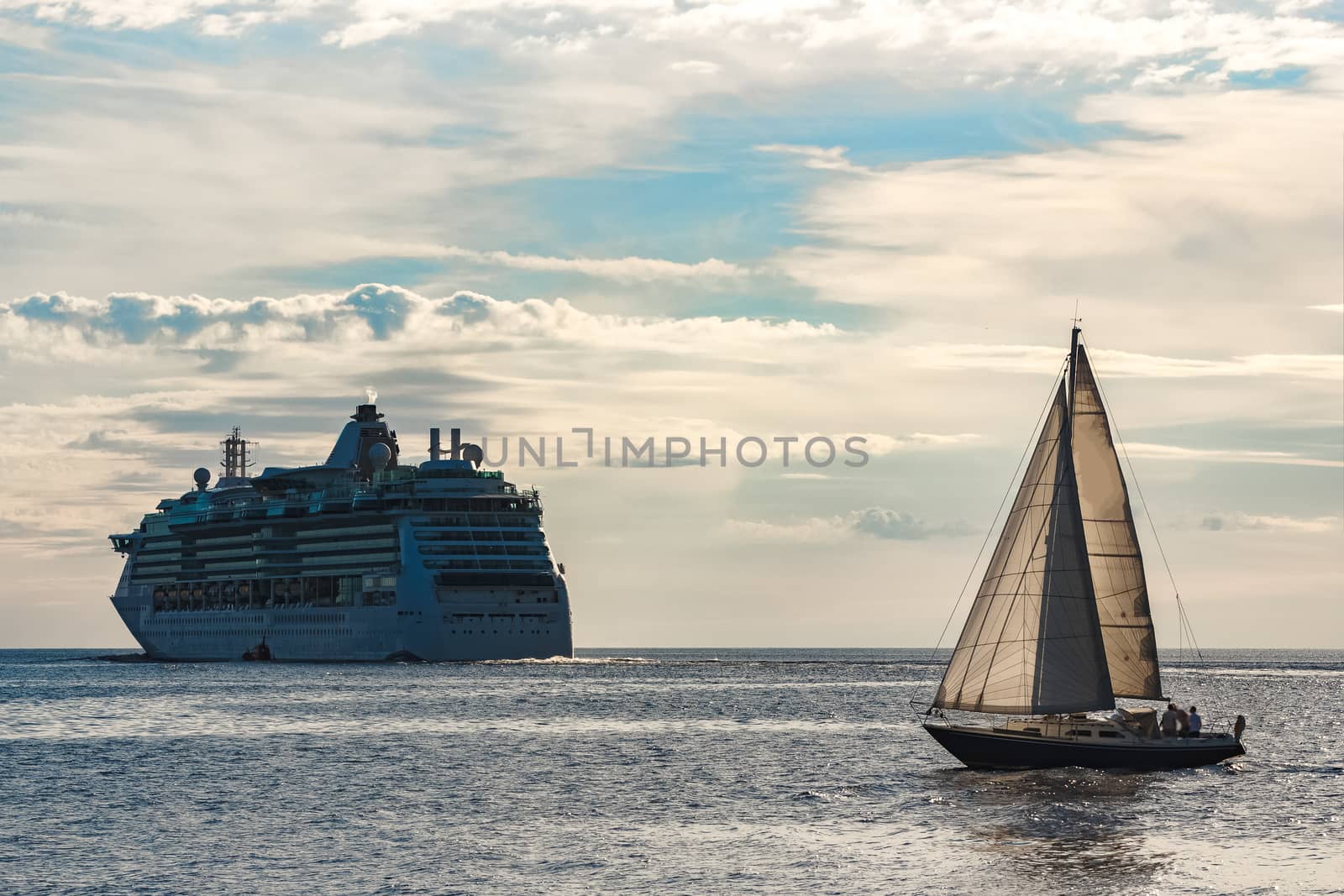 Blue sailboat traveling against the cruise liner in Riga